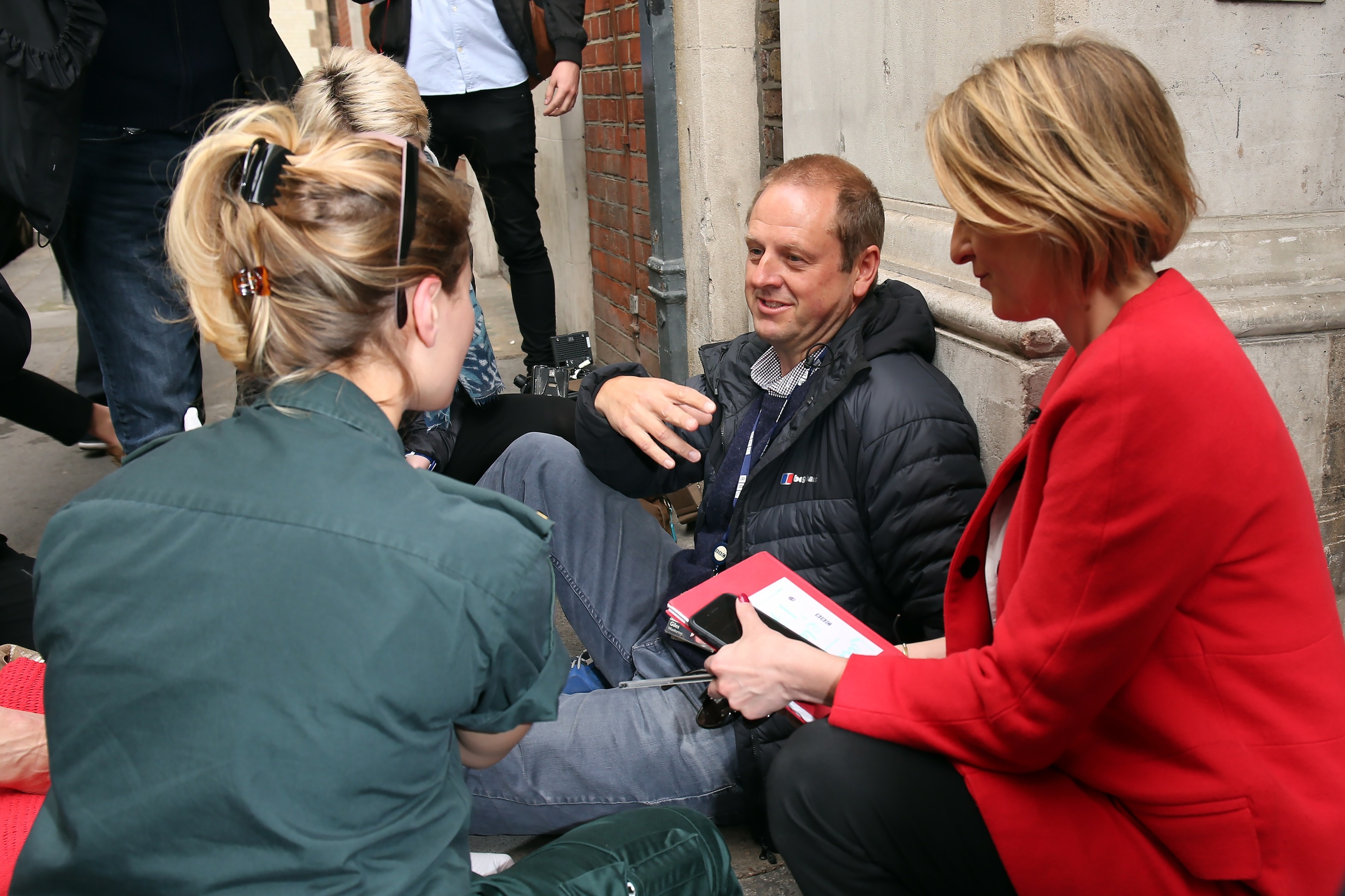 BBC Cameraman Giles Wooltorton is helped by Ambulance staff after reportedly being hit by Labour Leader Jeremy Corbyn's vehicle outside Savoy Place, as BBC reporter Laura Kuenssberg (R) looks on (Neil P. Mockford/Getty Images)
