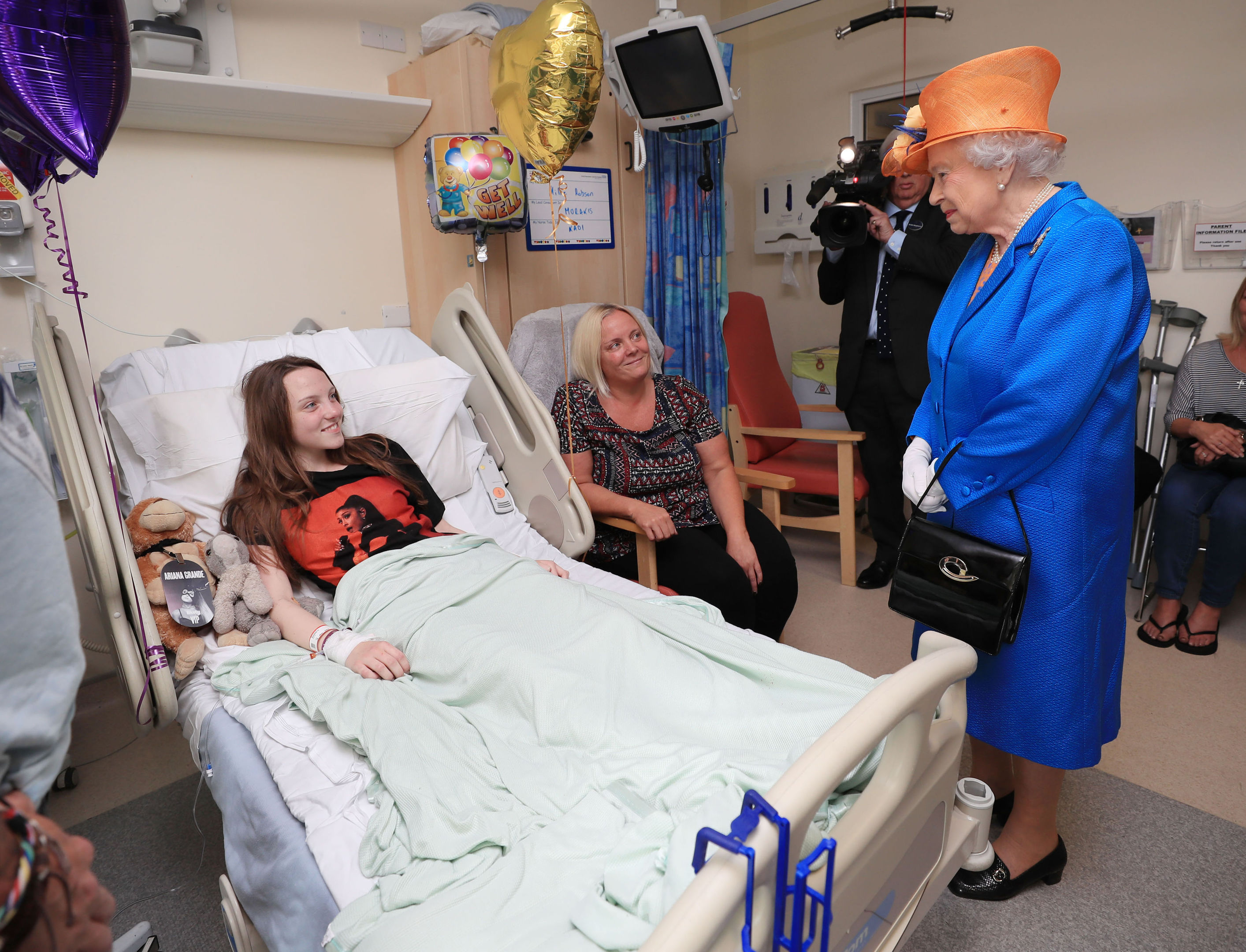 Queen Elizabeth II speaks to Millie Robson, 15, from Co Durham, and her mother, Marie, during a visit to the Royal Manchester Children's Hospital to meet victims of the terror attack in Manchester (Peter Byrne/WPA Pool/Getty Images)