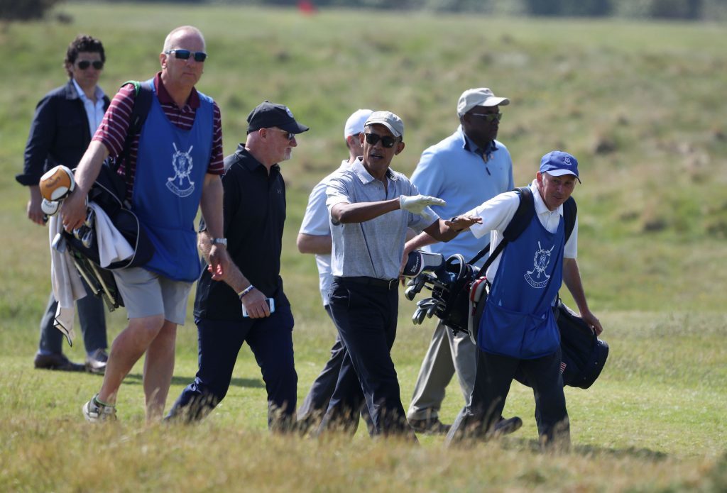 Former US president Barack Obama speaks with Sir Tom Hunter (black hat) as they move to the next hole (Andrew Milligan/PA Wire)