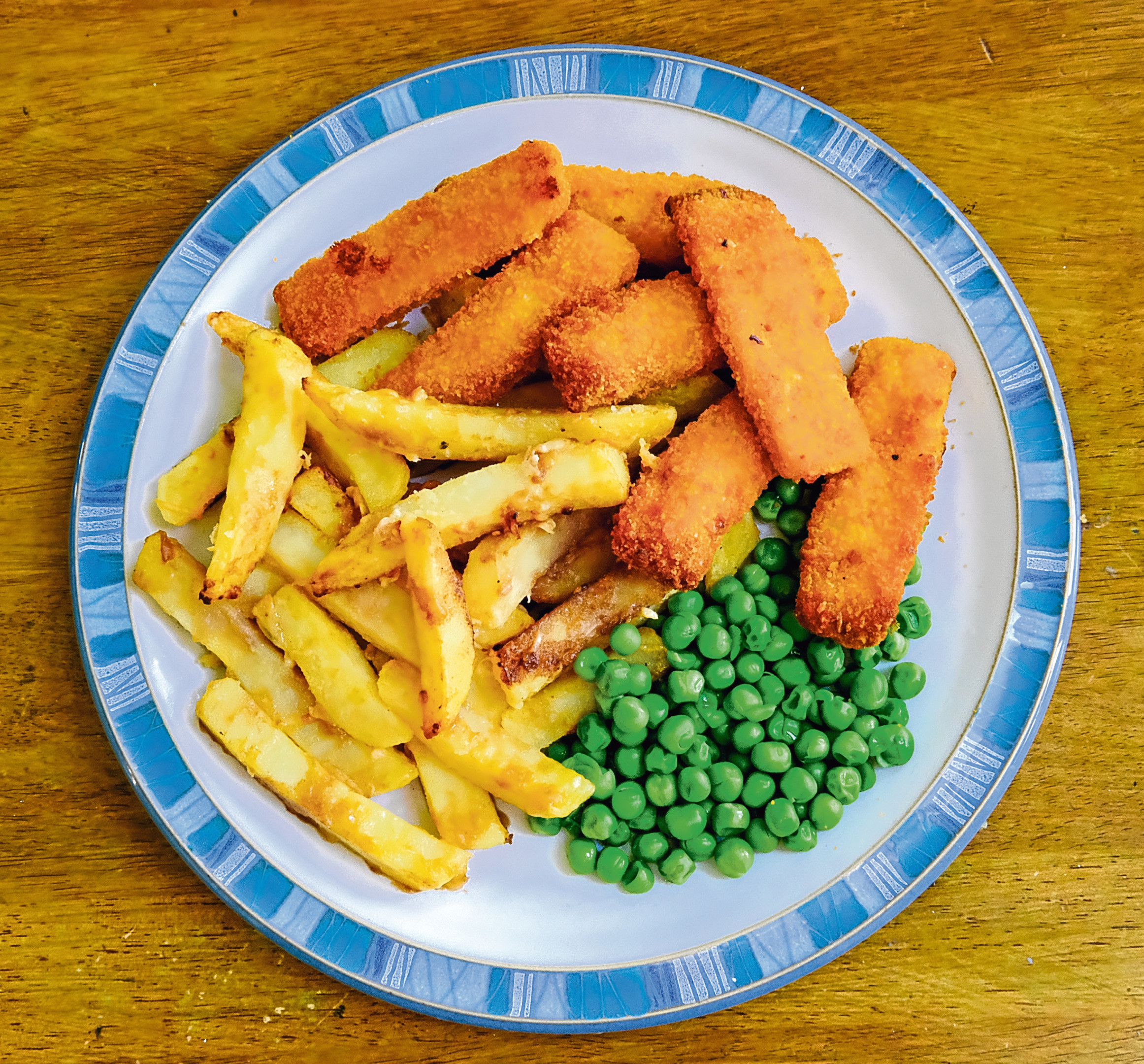 Traditional Fish fingers and Potato Chips, together with garden peas.