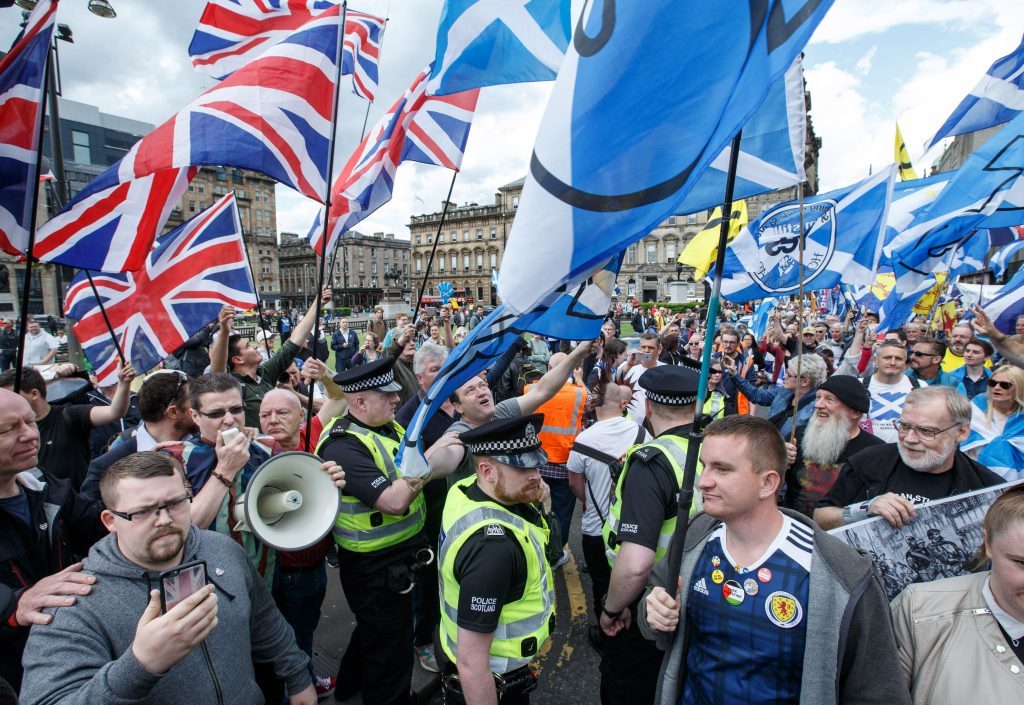 The march is met in George Square by a small band waving Union flags (Robert Perry/PA Wire)