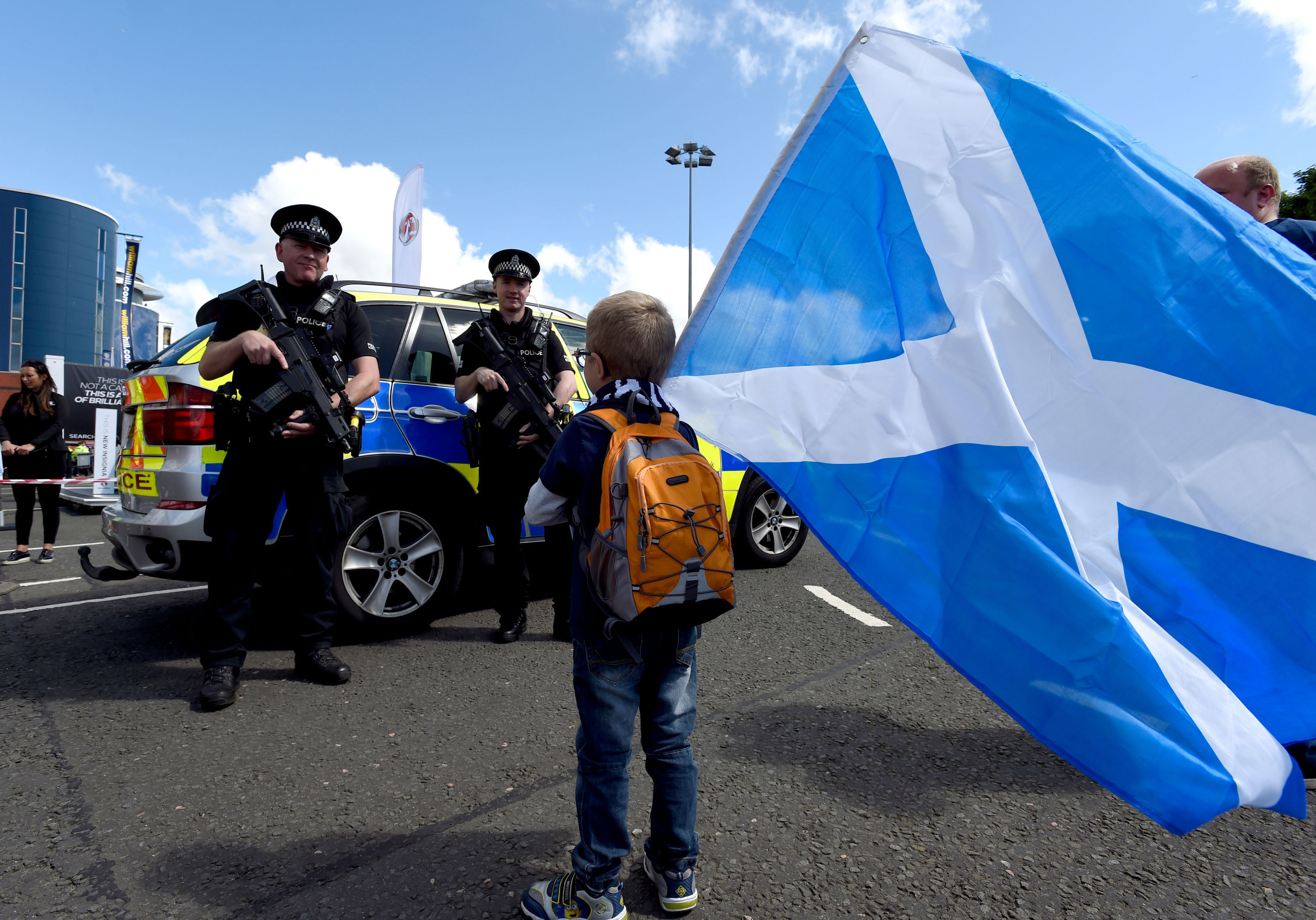 Armed police near a young fan holding a Scotland flag outside the ground ahead of the 2018 FIFA World Cup qualifying, Group F match at Hampden Park, Glasgow. (Ian Rutherford/PA Wire.)