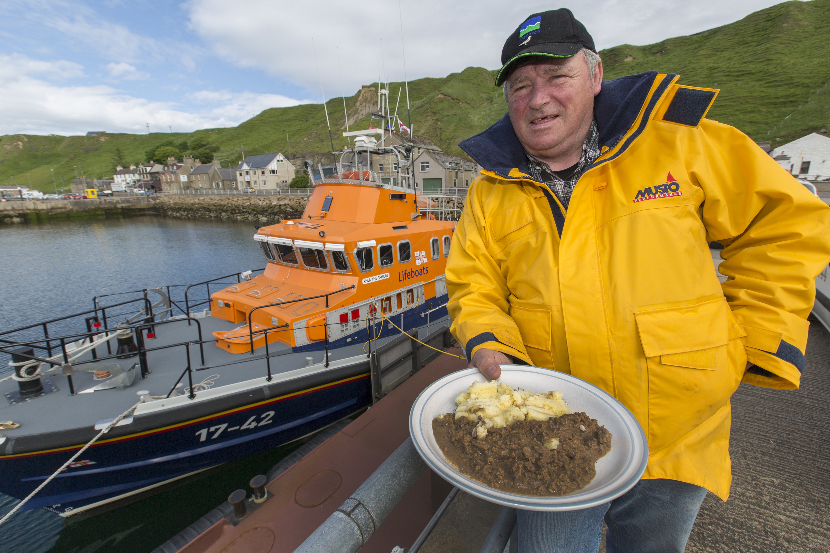 Thurso lifeboat coxswain William (Wing) Munro, with a plate of mince and tatties, awaiting the arrival of the gull he nursed back to health (Robert MacDonald / Northern Studios)