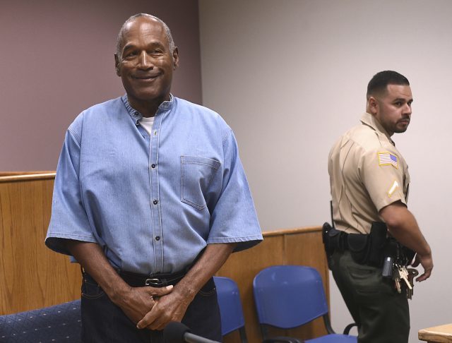 Former NFL star OJ Simpson enters for his parole hearing at the Lovelock Correctional Center (Jason Bean/AP)