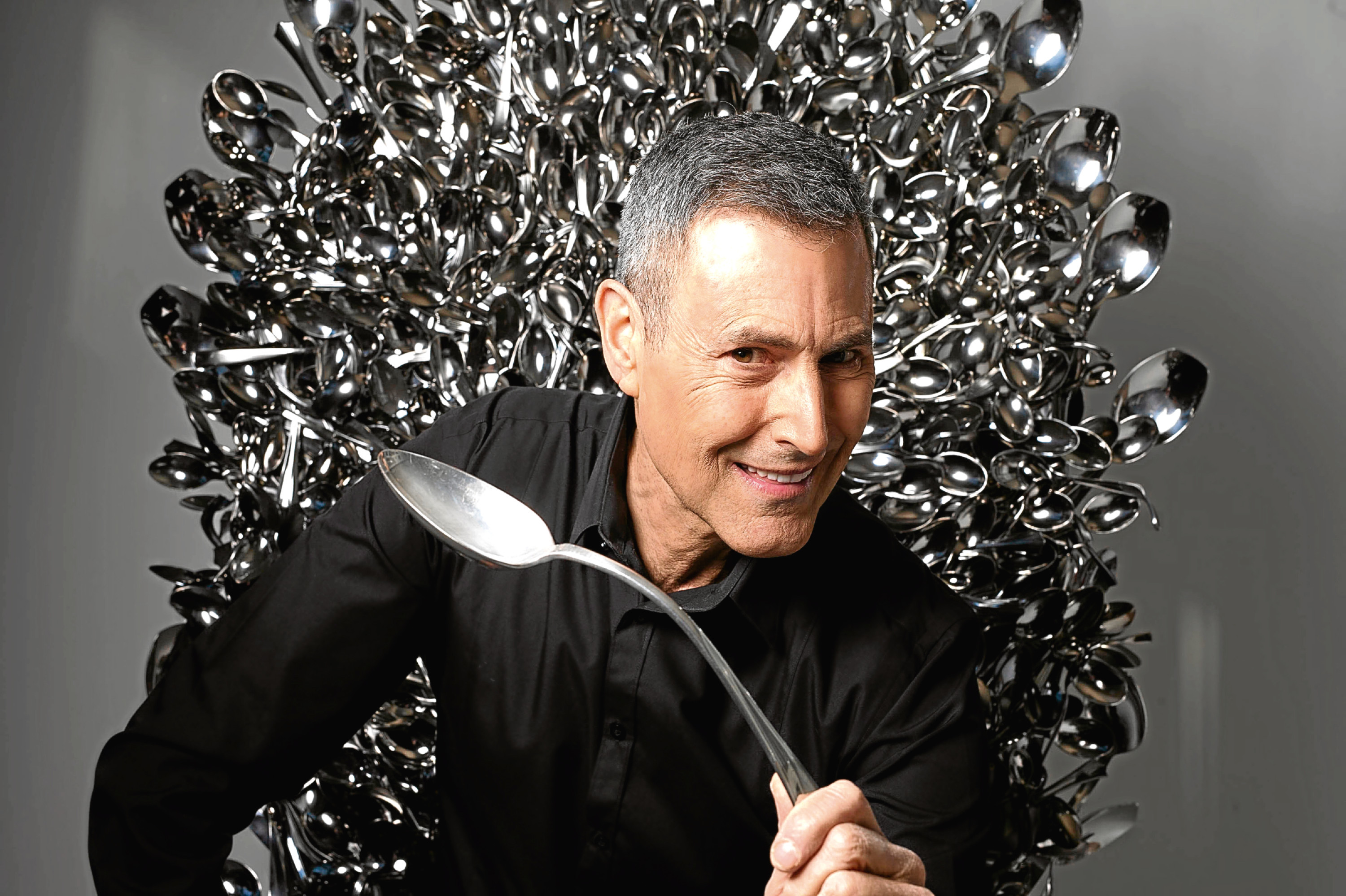 Uri Geller sits on a throne of spoons inspired by the television show Game of Thrones. (David Parry/PA Wire)