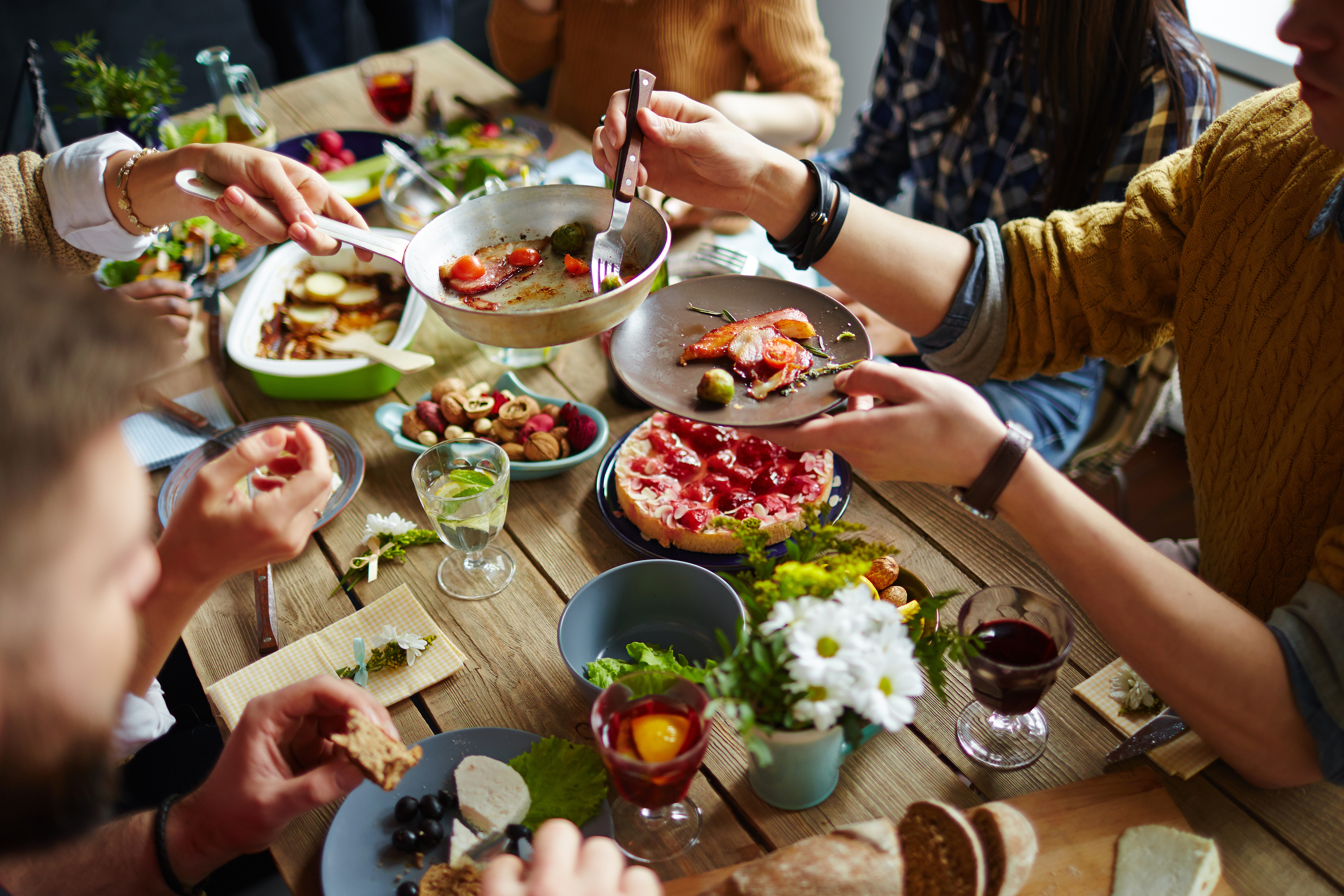 People sitting at dining table and eating (iStock)