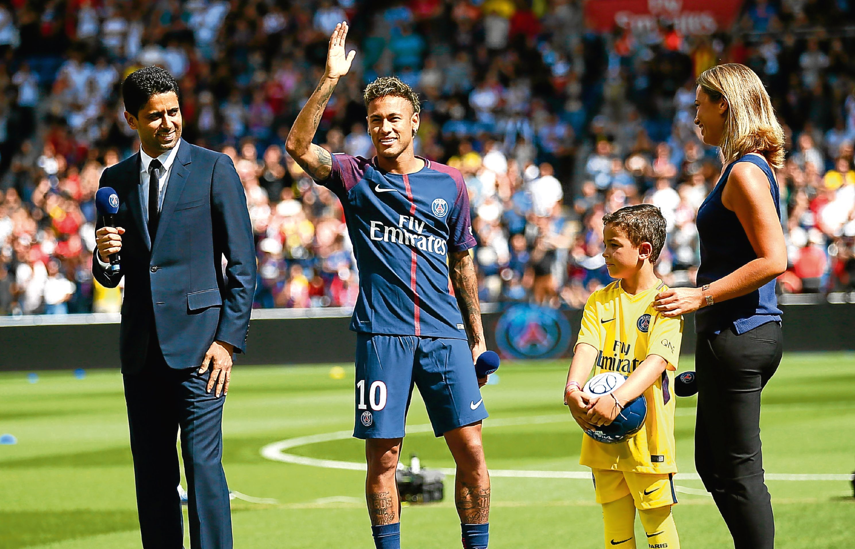 Neymar waves to fans as he stands next to PSG president Nasser Ghanim Al-Khelaïfi at the Parc des Princes (AP Photo/Francois Mori)