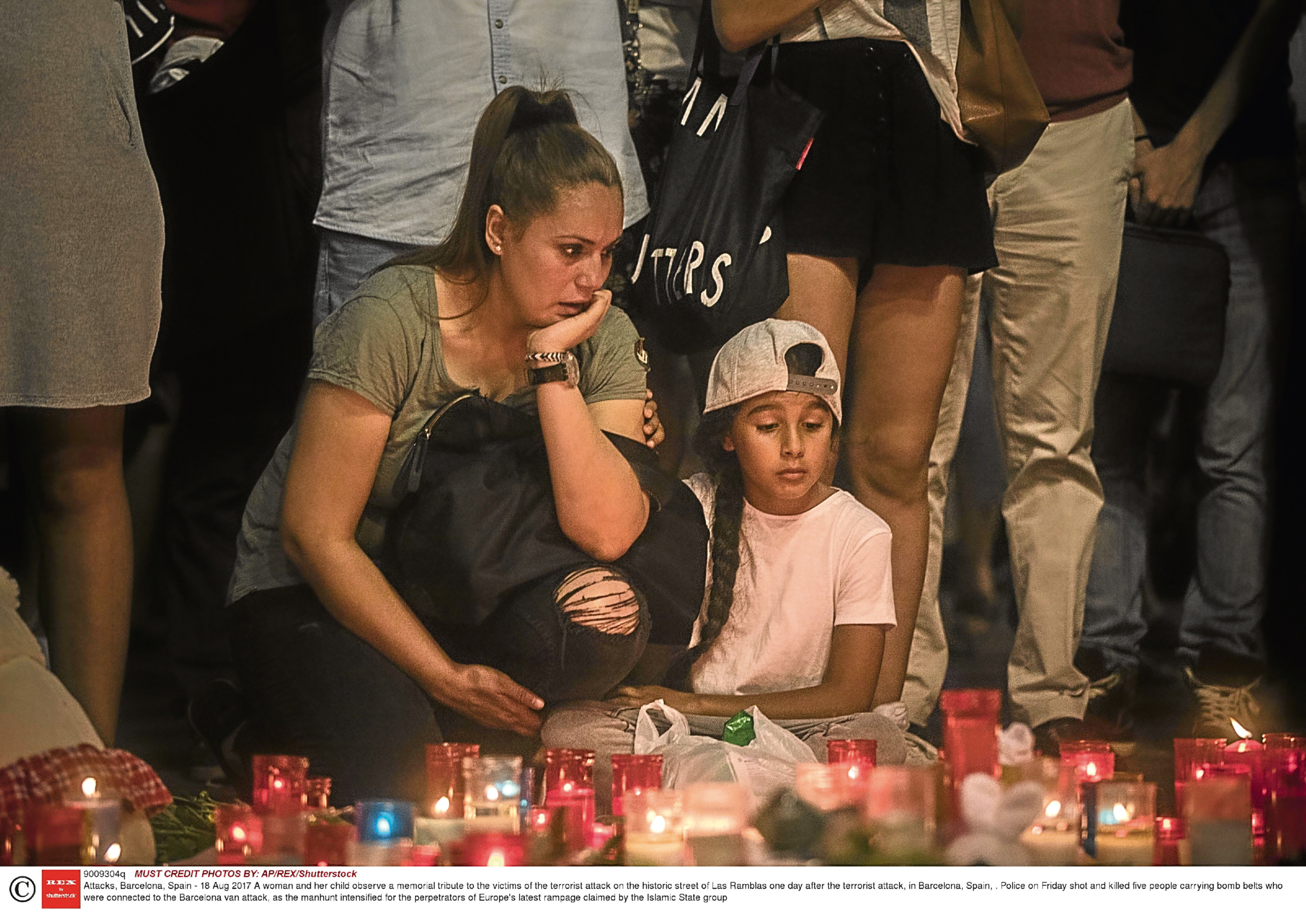 A woman and her child observe a memorial tribute to the victims of the terrorist attack, in Barcelona (AP/REX/Shutterstock)