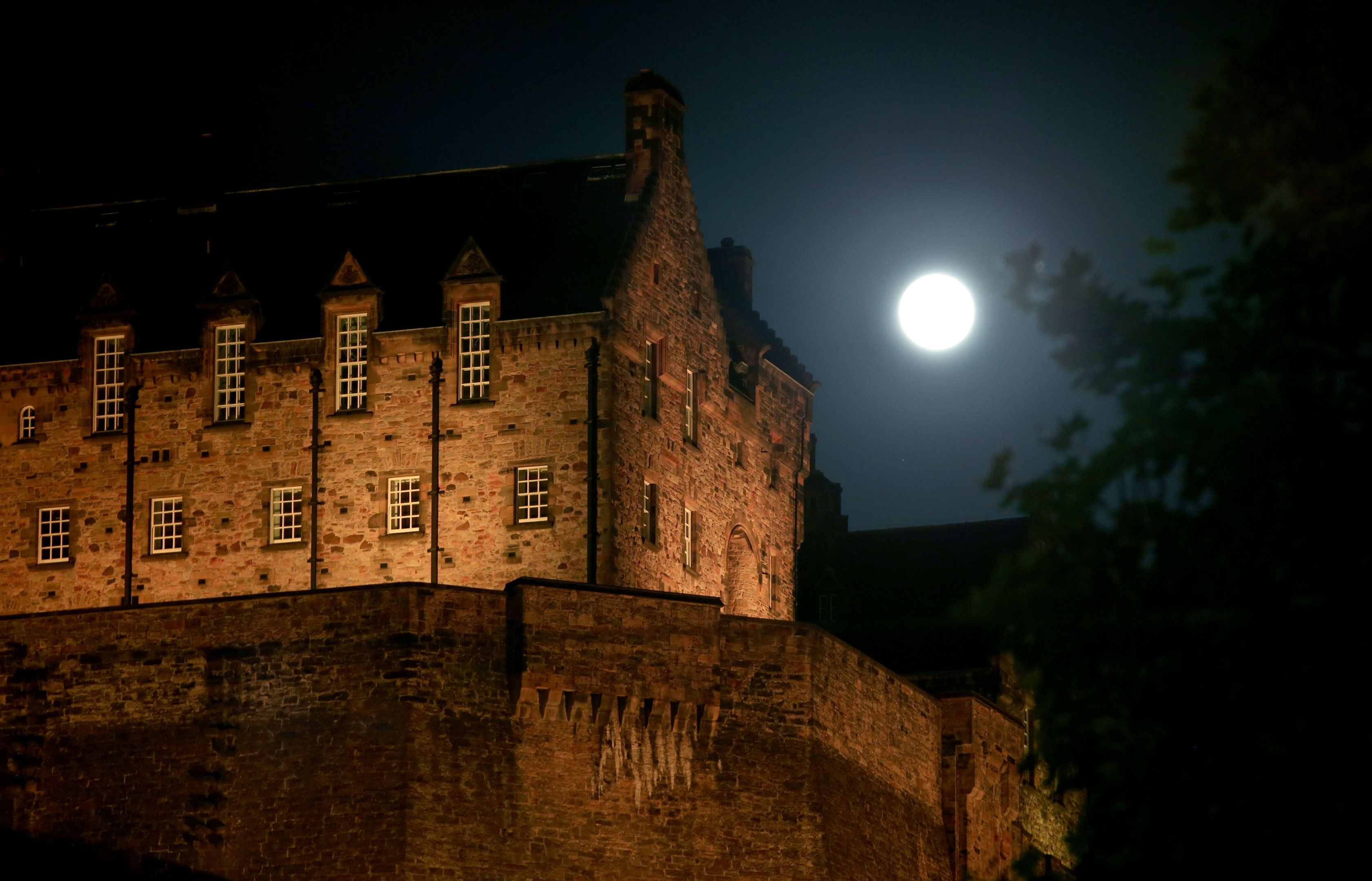 A full moon, known as a Sturgeon Moon in the month of August, rises behind Edinburgh Castle. (Jane Barlow/PA Wire)