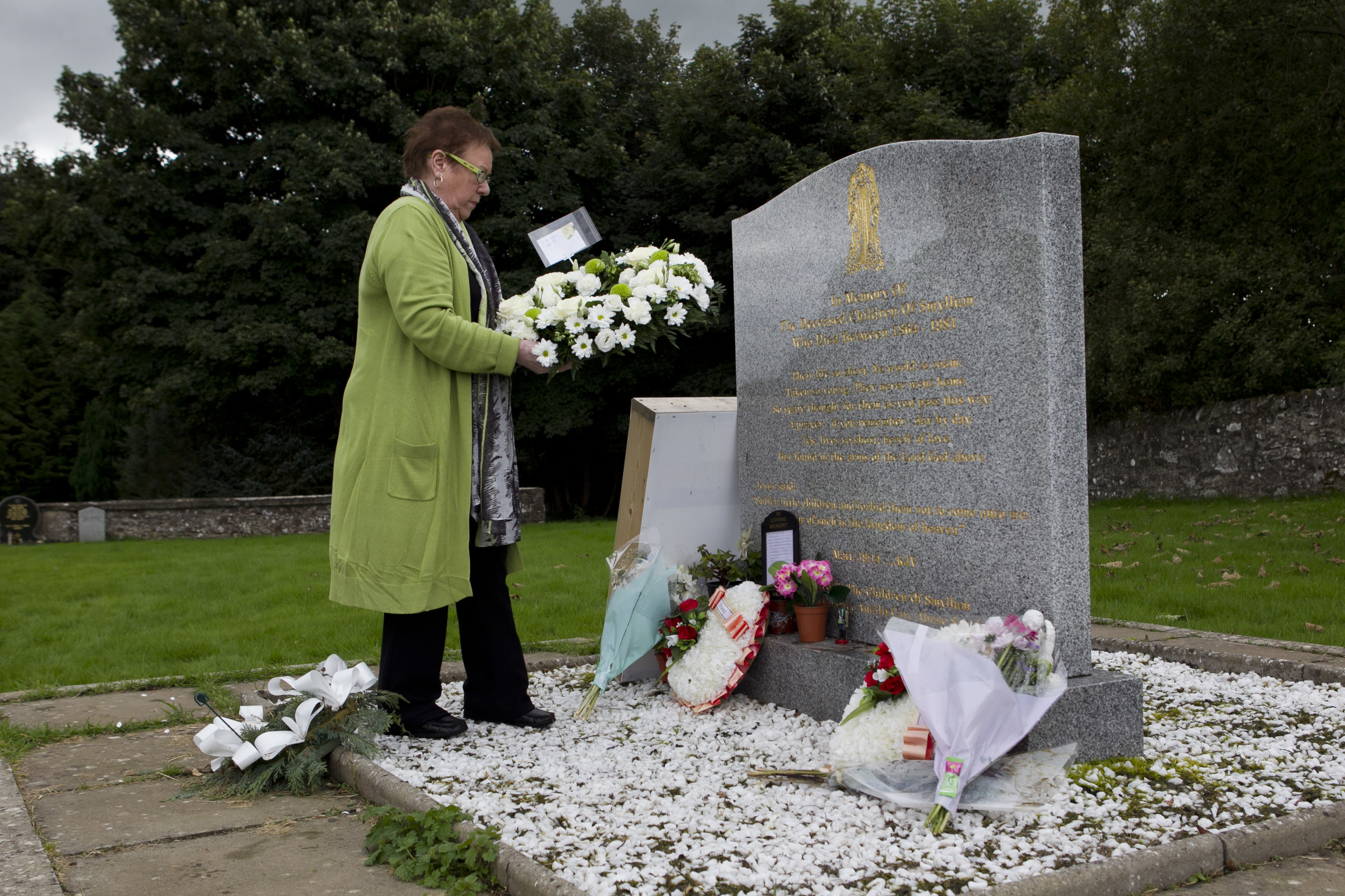 Former Smyllum resident Josie Drage-Dawes laying a wreath at the headstone for the children who died at Smyllum Park Orphange (Andrew Cawley / DC Thomson)