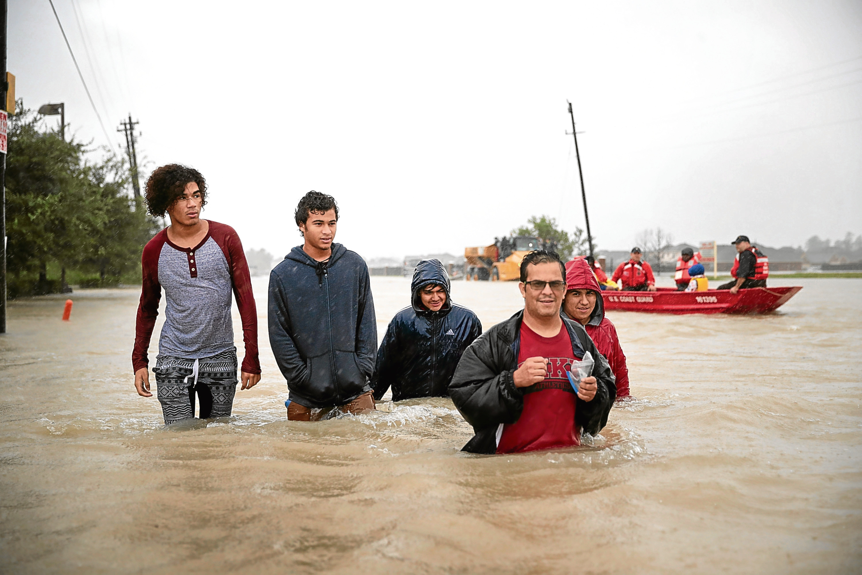 People make their way out of a flooded neighborhood after it was inundated with rain water (Scott Olson/Getty Images)