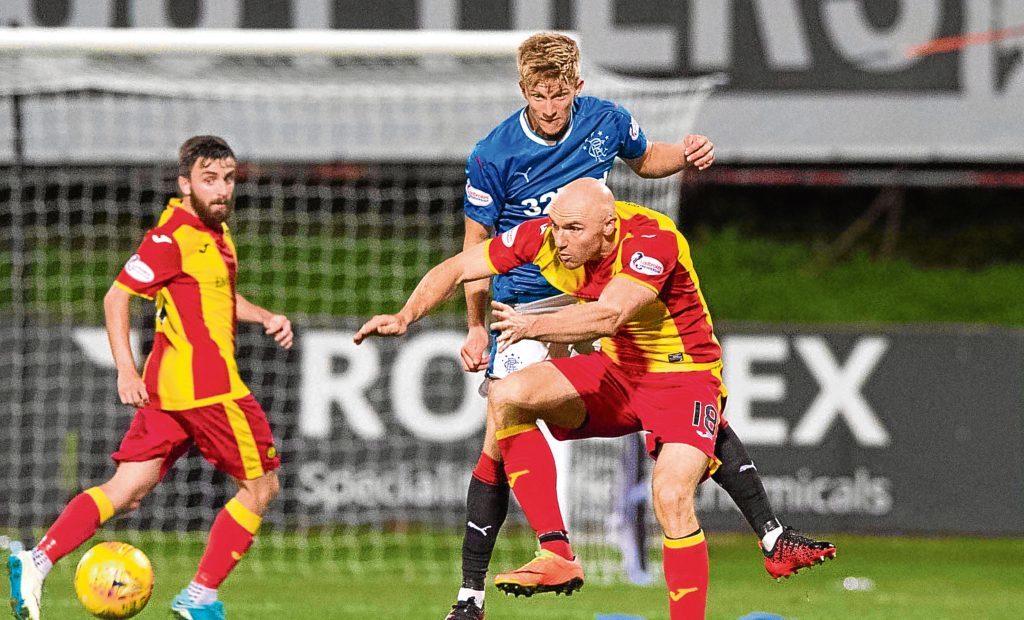 Rangers' Ross McCrorie (left) heads clear under pressure from Partick's Conor Sammon (SNS)