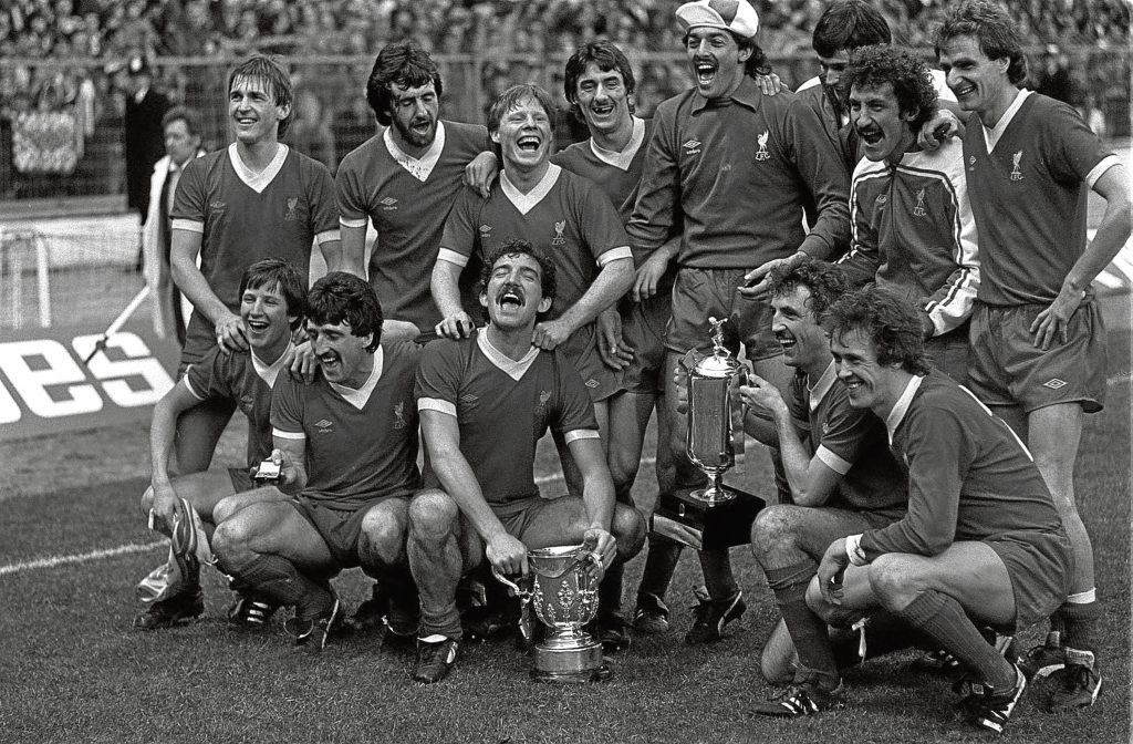 Liverpool team celebrate their football match League Milk Cup Final win over Tottenham Hotpsur, at Wembley in London. * Pictured holding the old League Cup is Captain Graeme Souness and Alan Kennedy (squatting right) holding the new Milk Cup. Goal scorers are : Ronnie Whelan (far left, squatting) and Ian Rush (fourth left standing) (PA)