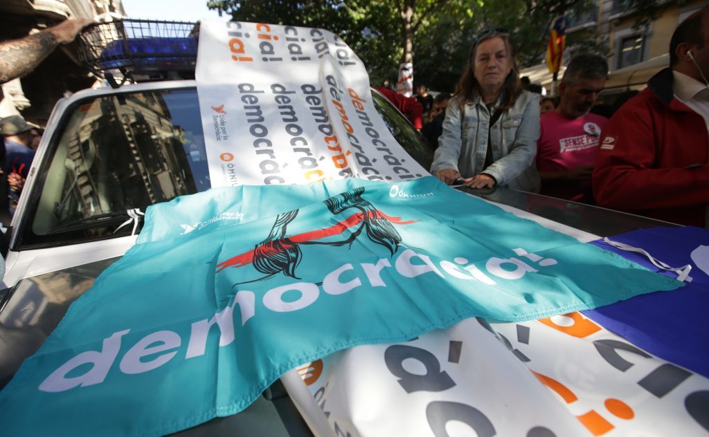 People hold placards as they protest in front of the Economy headquarters of Catalonia's regional government in Barcelona (Albert Llop/Anadolu Agency/Getty Images)