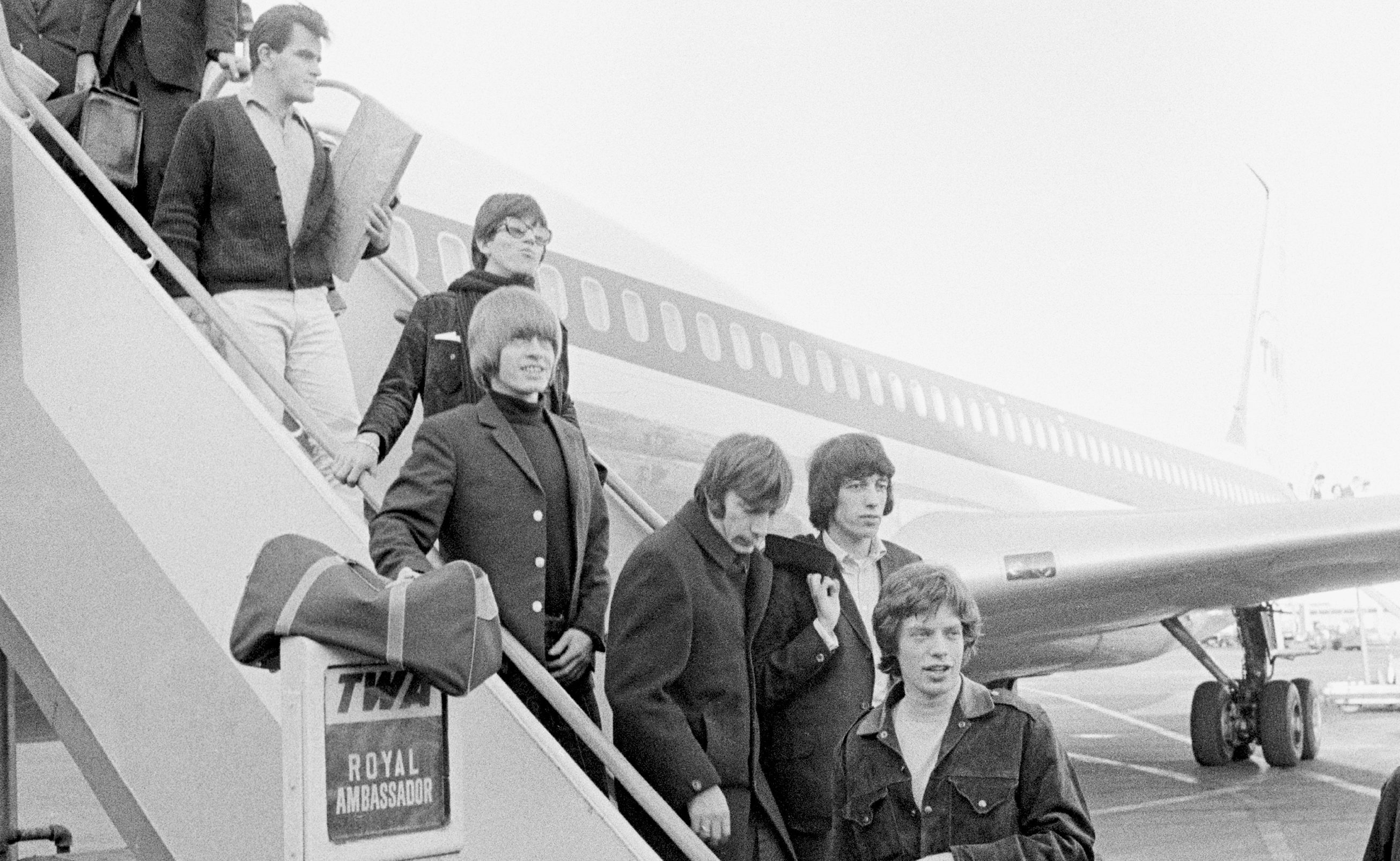 Ian Stewart (top) follows the band off a flight on the Stones' 1965 US tour