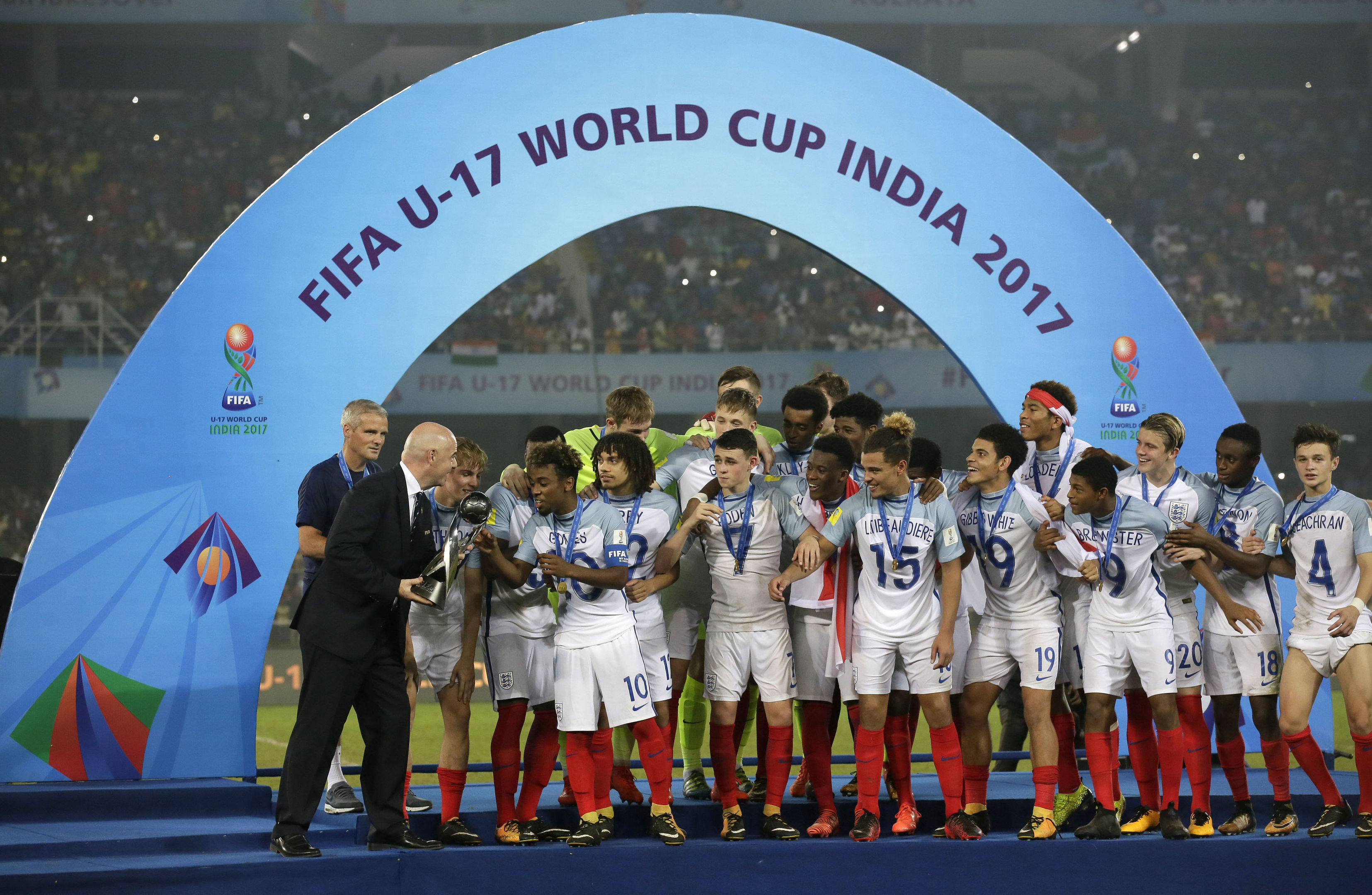 FIFA President Gianni Infantino hands the trophy to England's Angel Gomes after they won the FIFA U-17 World Cup in Kolkata, India, Saturday, Oct. 28, 2017. (AP Photo/Anupam Nath)