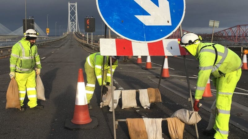 Workers weigh down signs on the Forth Road Bridge (Amey /PA Wire)