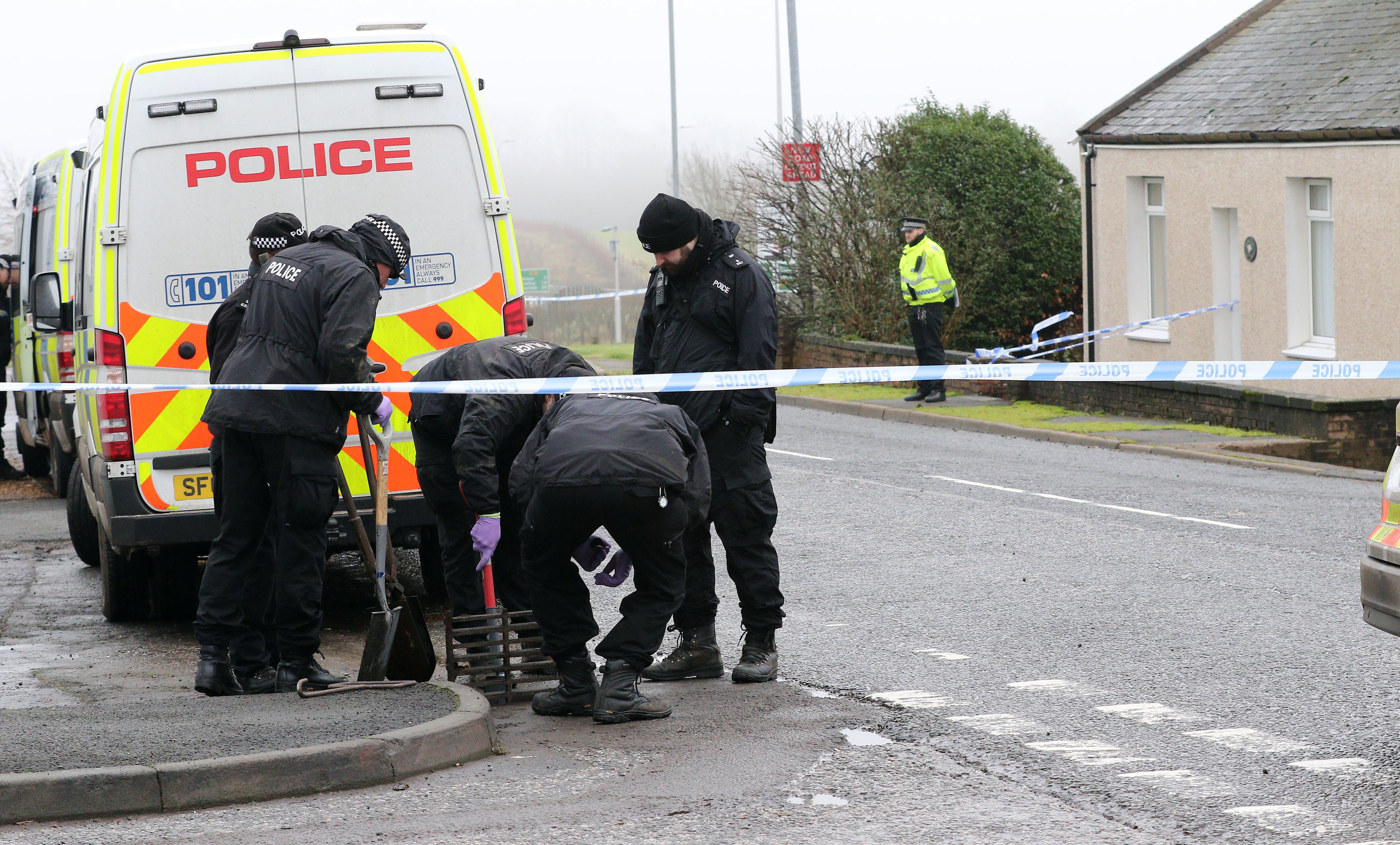Police at Carrutherstown examining and clearing drains opposite the vicitim's house (Drew Geddes)