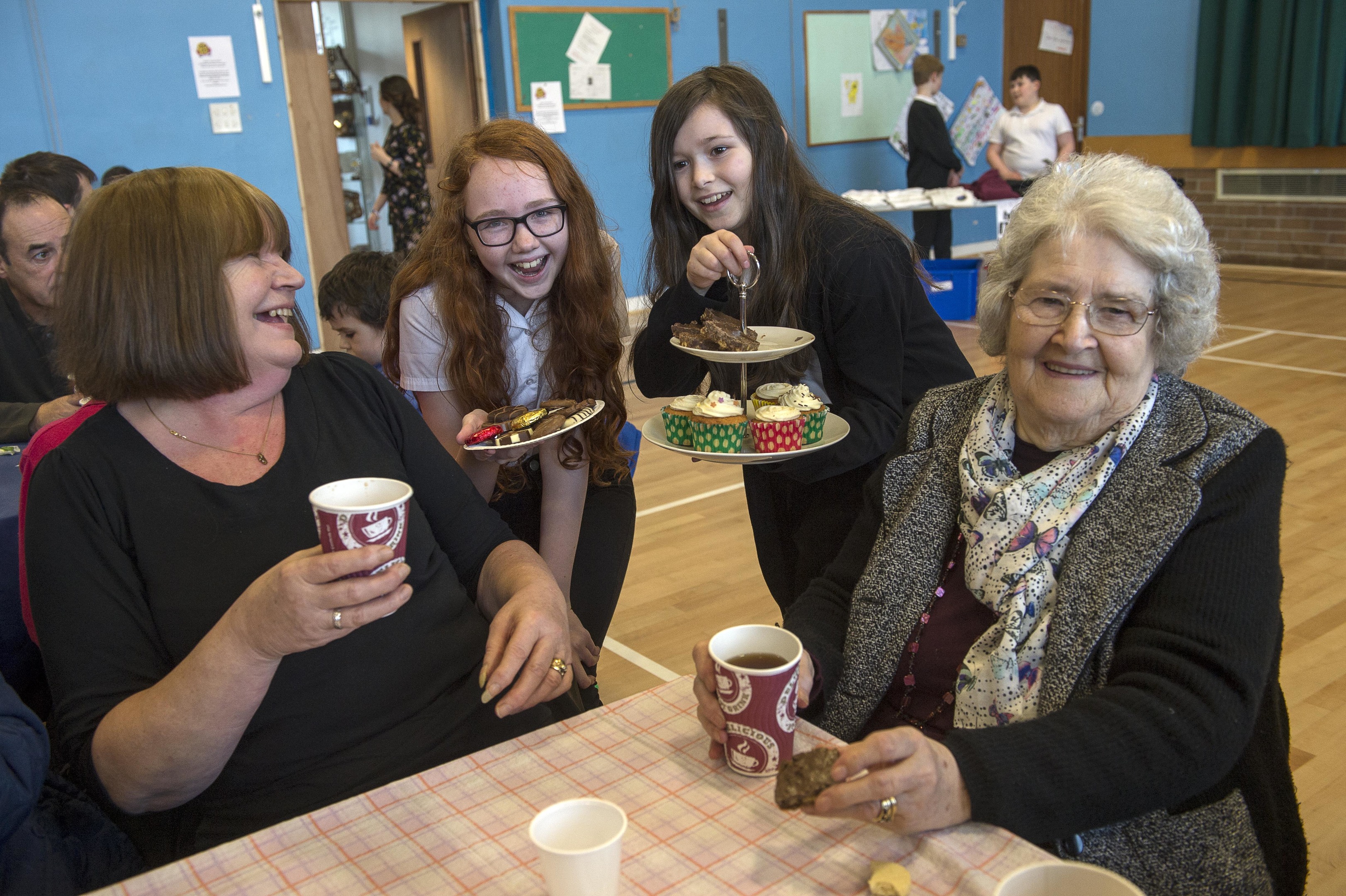 Pupils Rebecca Campbell and Charlotte Mackenzie share a laugh and a some home bakes with Christine Macrae and Agnes Macleod (Trevor Martin)