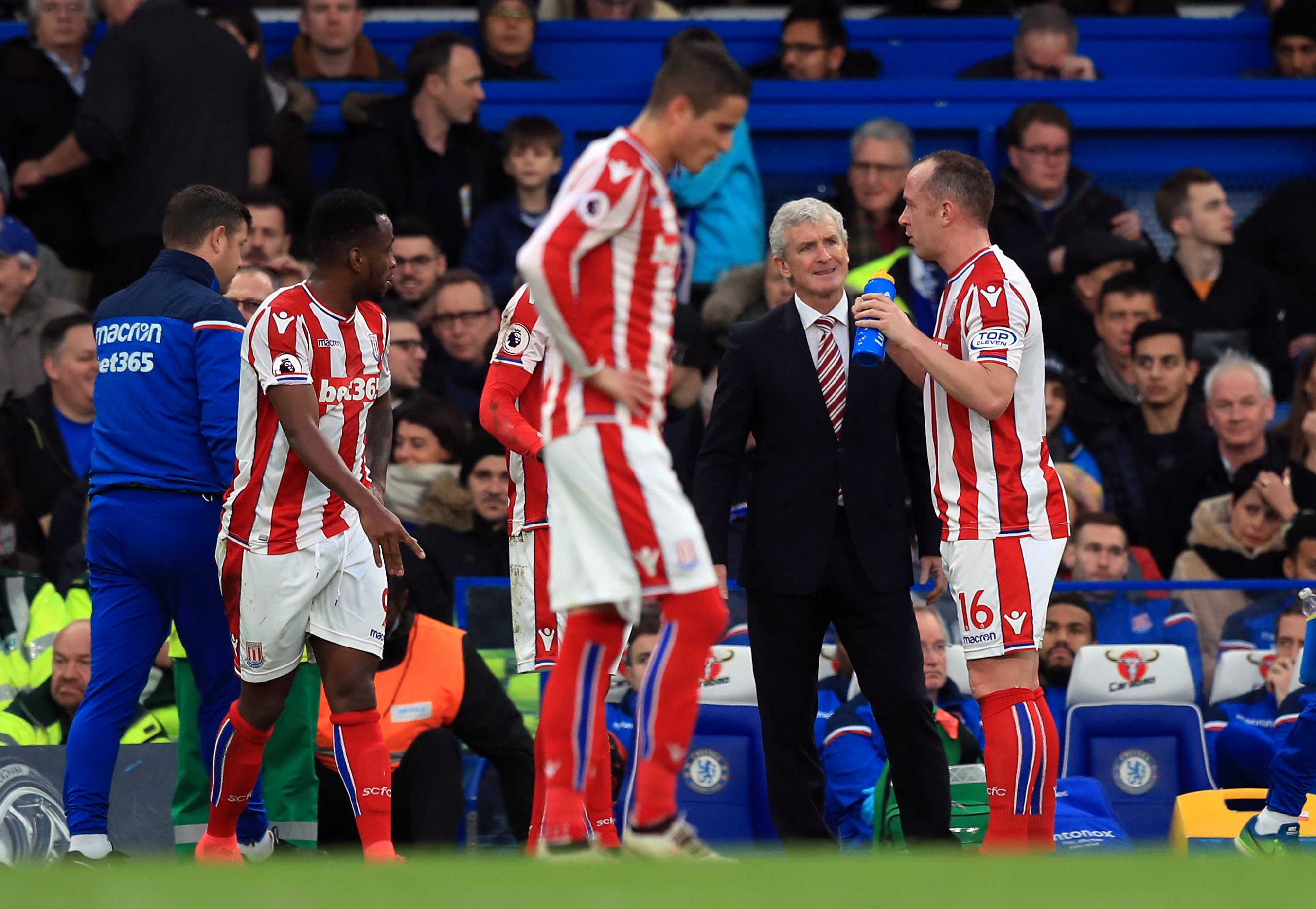 Stoke City manager Mark Hughes speaks to Charlie Adam during the Premier League match at Stamford Bridge, London (PA)