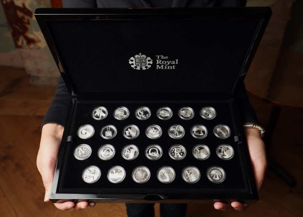 A Royal Mint employee displays 26 brand new 10 pence designs (Jonathan Brady/PA Wire)