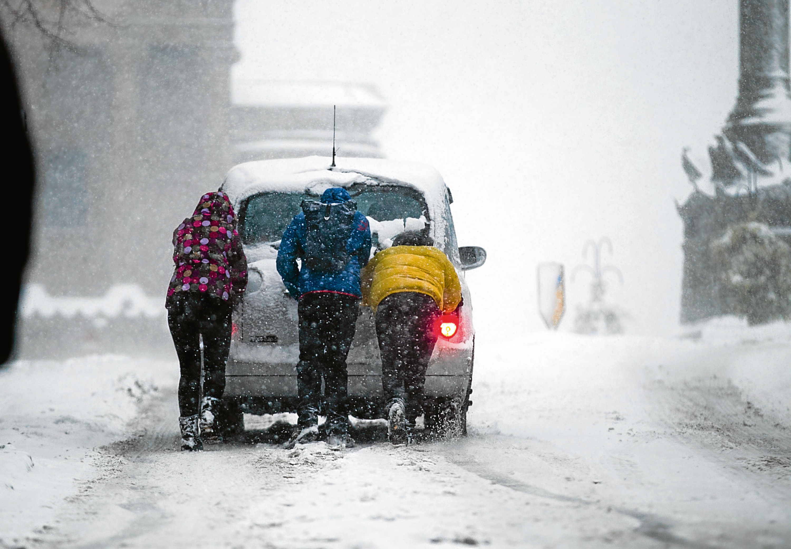 Passengers push a taxi up a hill in Battlefield, Glasgow (Andrew Cawley / DC Thomson)