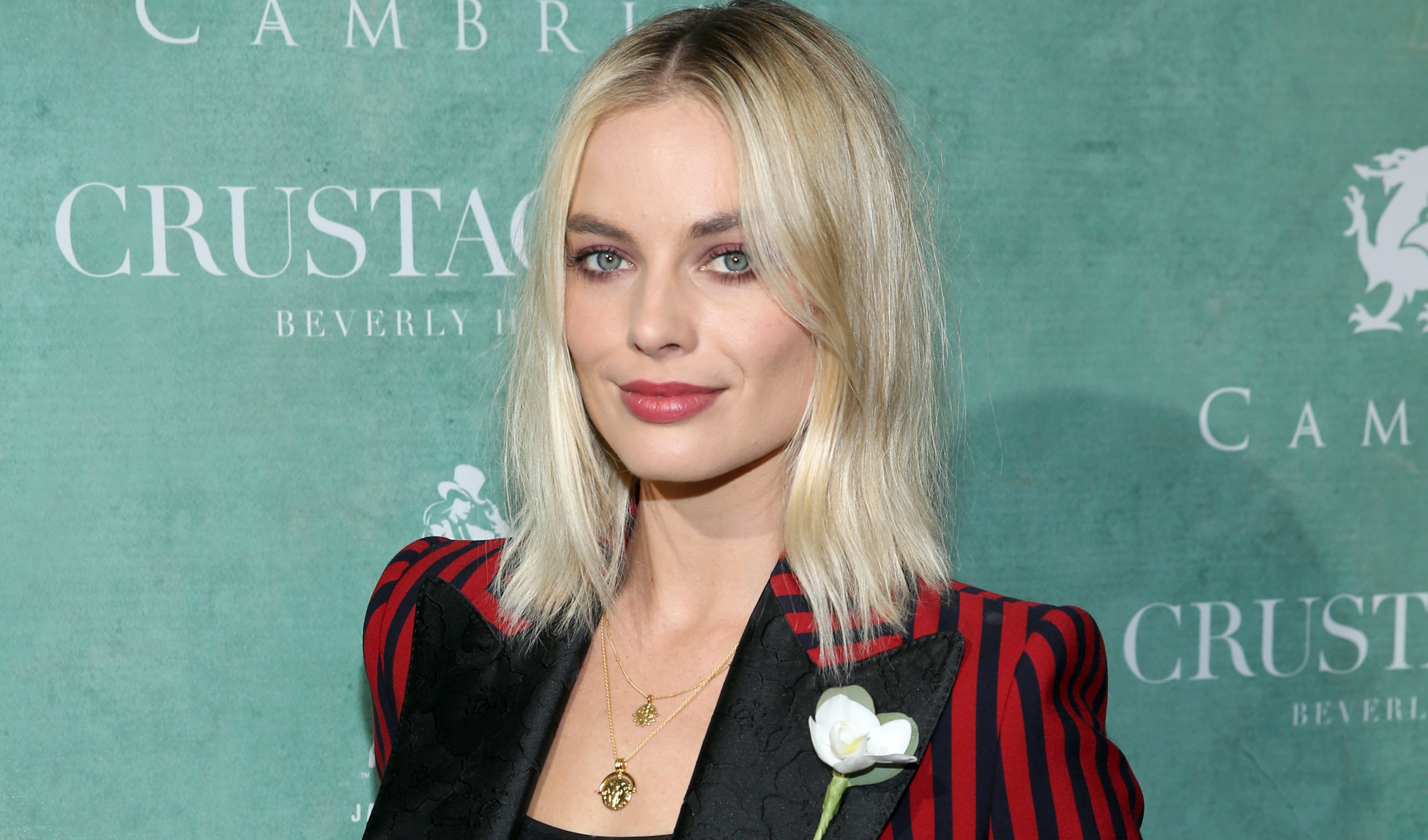 Oscar nominee Margot Robbie wears a white rose to an event in LA on Friday  (Phillip Faraone/Getty Images)