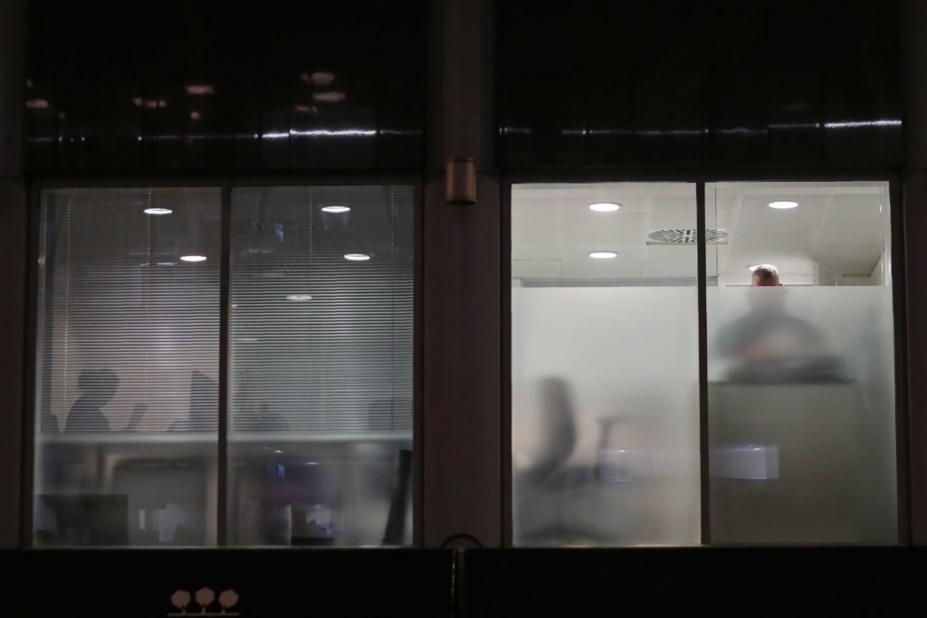 People are seen through blinds searching inside the offices of Cambridge Analytica (DANIEL LEAL-OLIVAS/AFP/Getty Images)