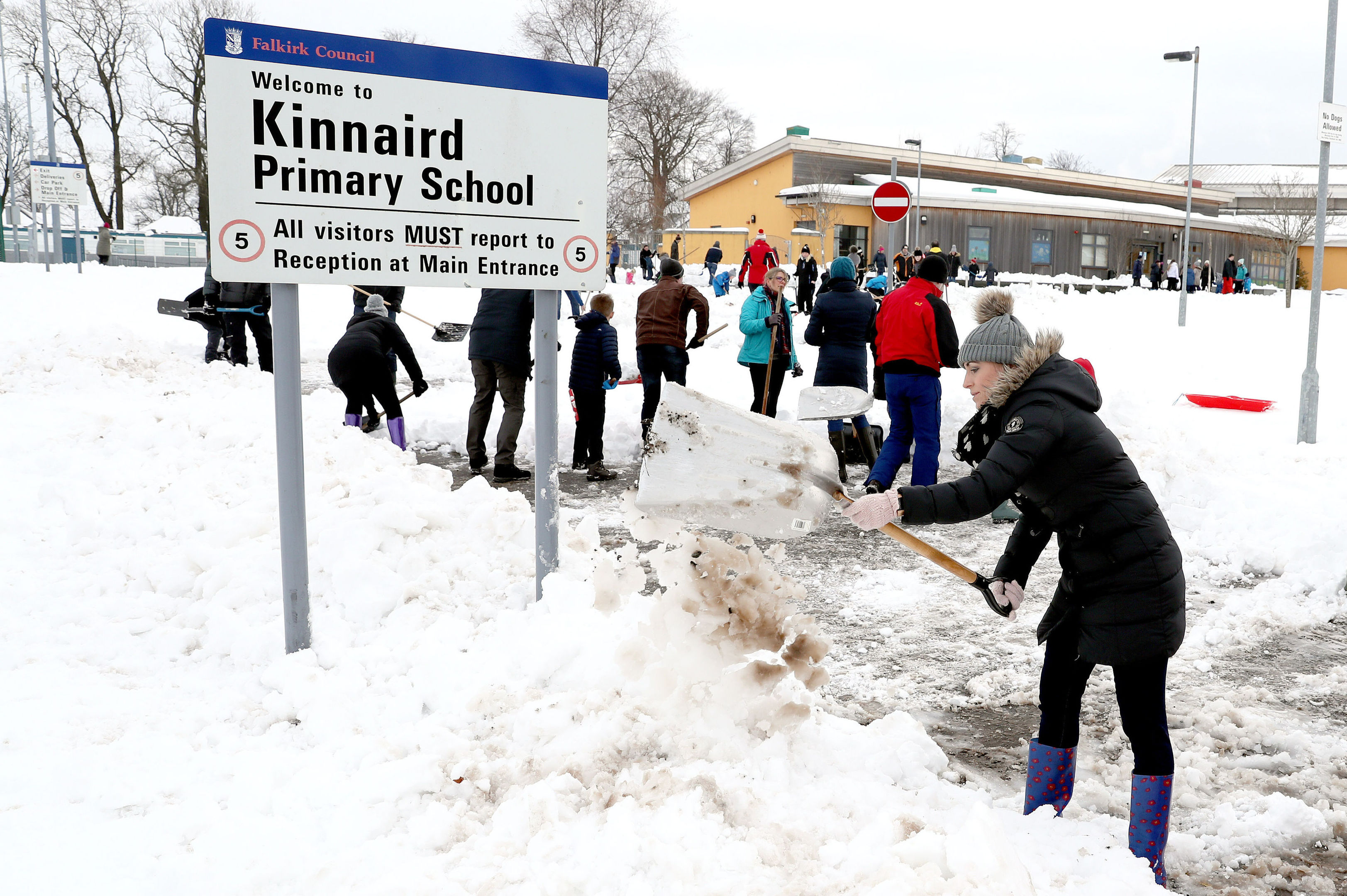 Parents, teachers and the local community of Larbert  clearing the grounds of Kinnaird Primary School (Andrew Milligan/PA Wire)