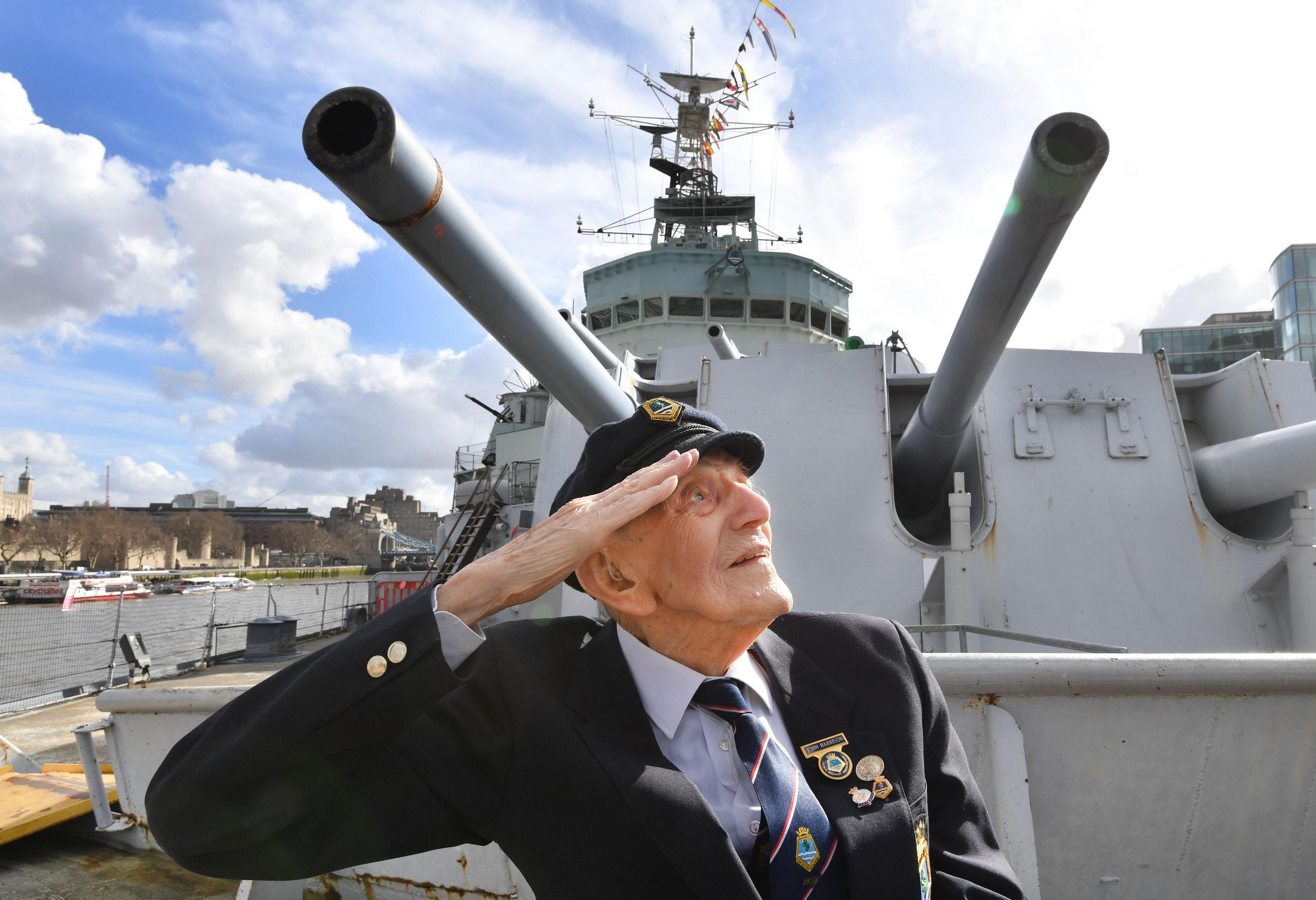 John Harrison aged 104, sits on the foredeck of HMS Belfast in front of gun turret A (John Stilwell/PA)