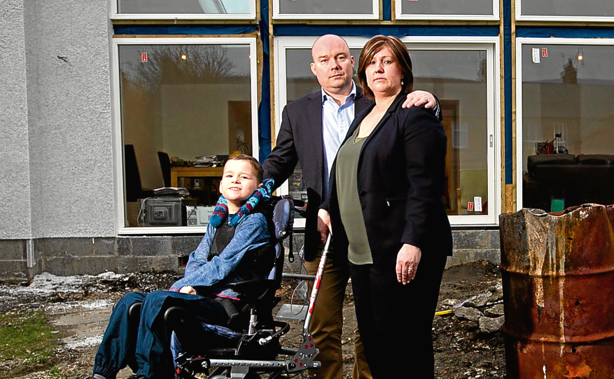Paul and Susan Morris, and their son, Lachlan in their back garden, with extension behind them (Andrew Cawley / DC Thomson)