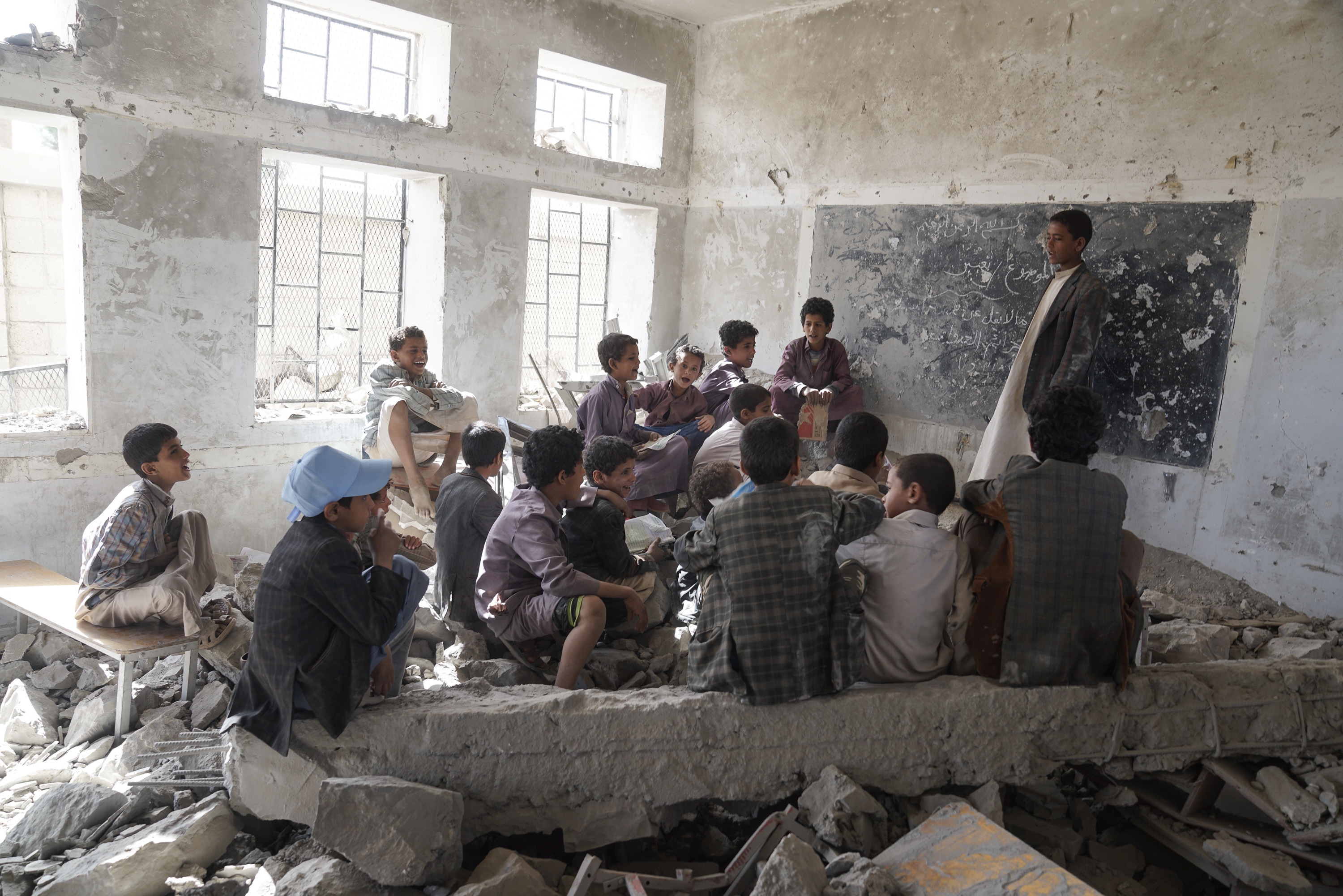 Children sit in a former classroom in the Aal Okab school in Yemen which was bombed out in 2015 (Giles Clarke for UN OCHA / Getty Images)