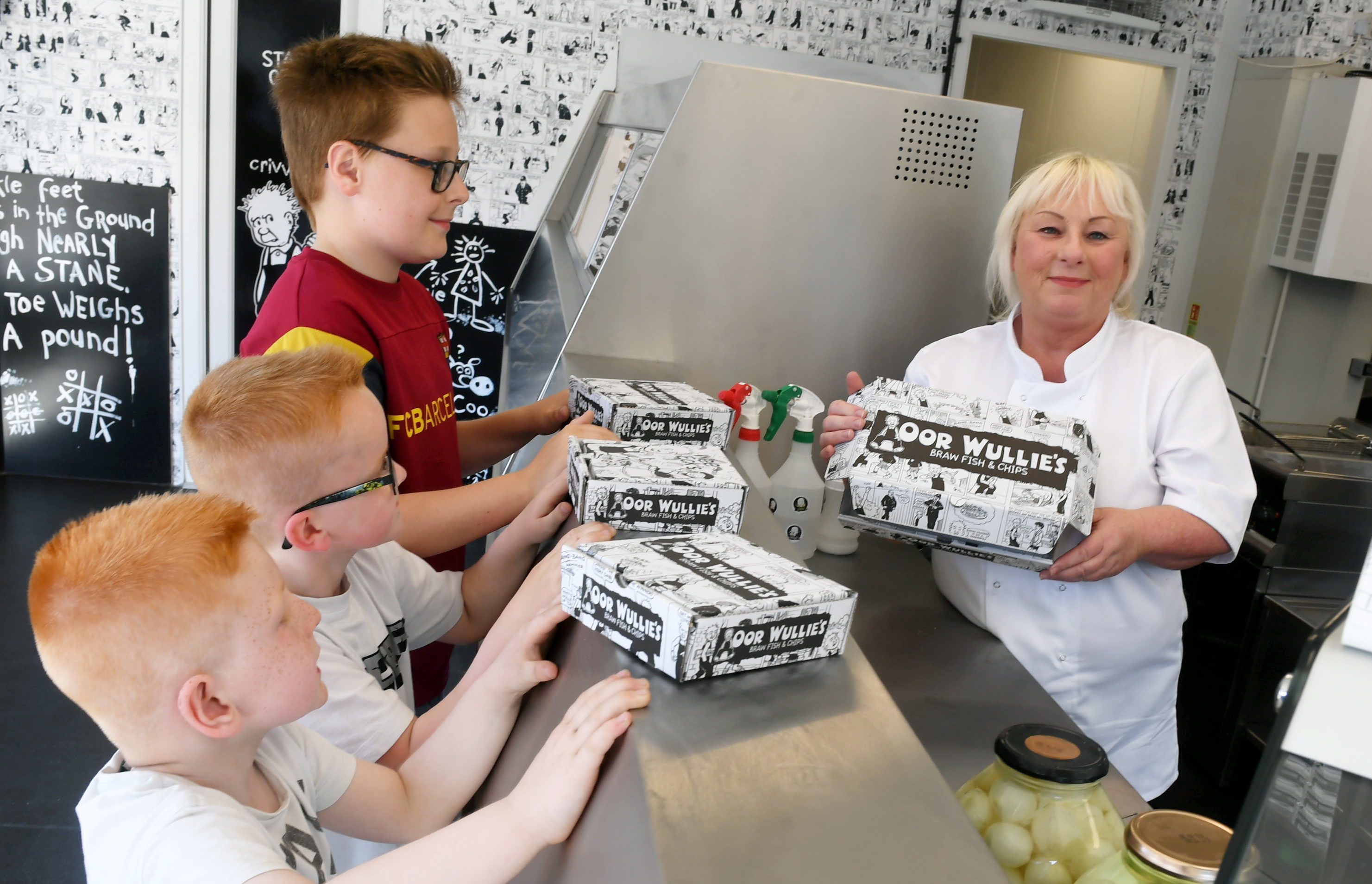 Sylvia Milne serving the first customers, from left, brothers, Lawrence, 11, Zak, 6 and Levi Jaffrey, 6 (Chris Sumner / DC Thomson)