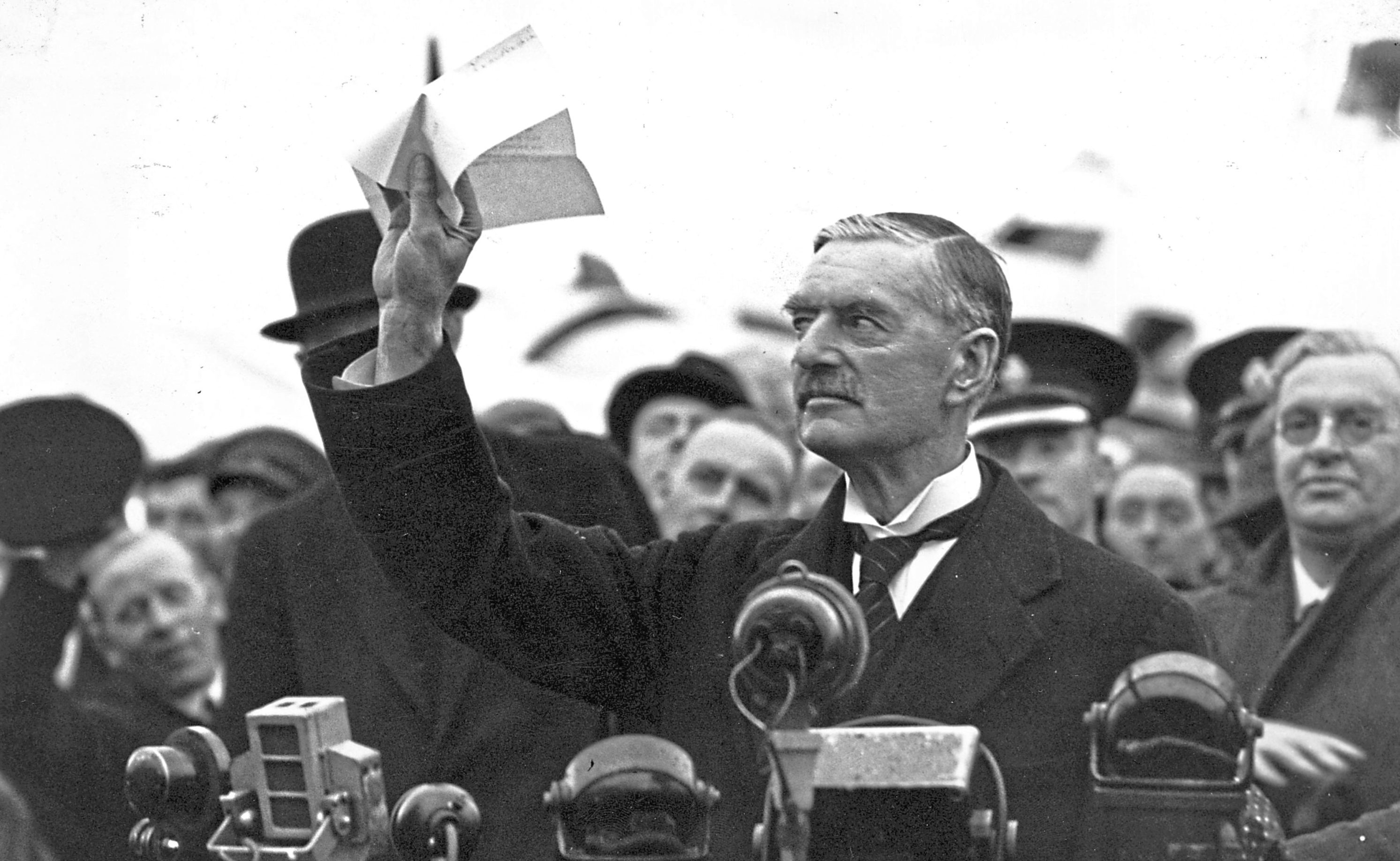 British statesman and prime minister Neville Chamberlain (1869 - 1940) at Heston Airport on his return from Munich after meeting with Hitler, making his 'peace in our time' address.   (Central Press/Getty Images)