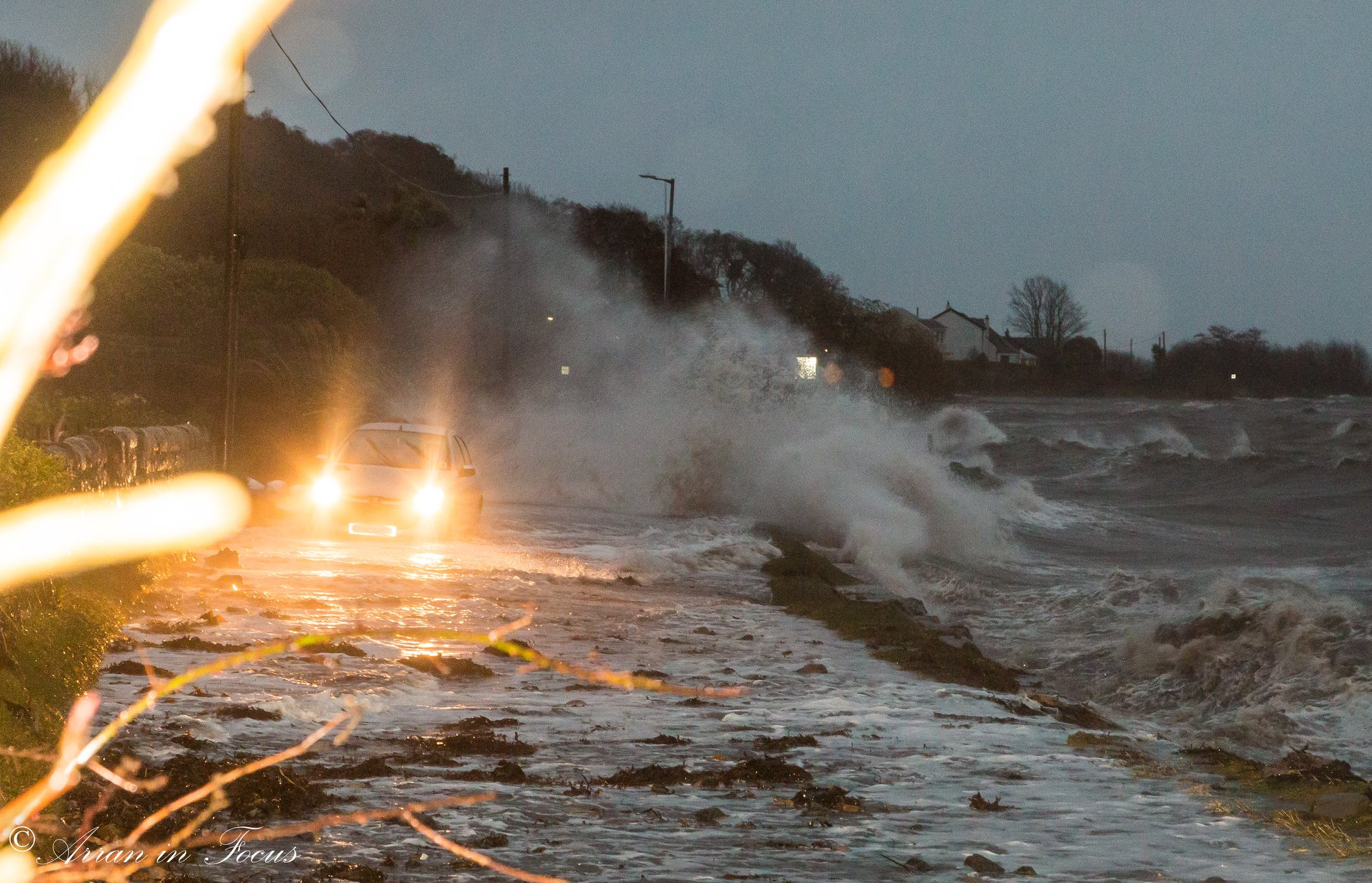 A car avoids surging waves on the Isle of Arran. (Arran in Focus Facebook Page.)