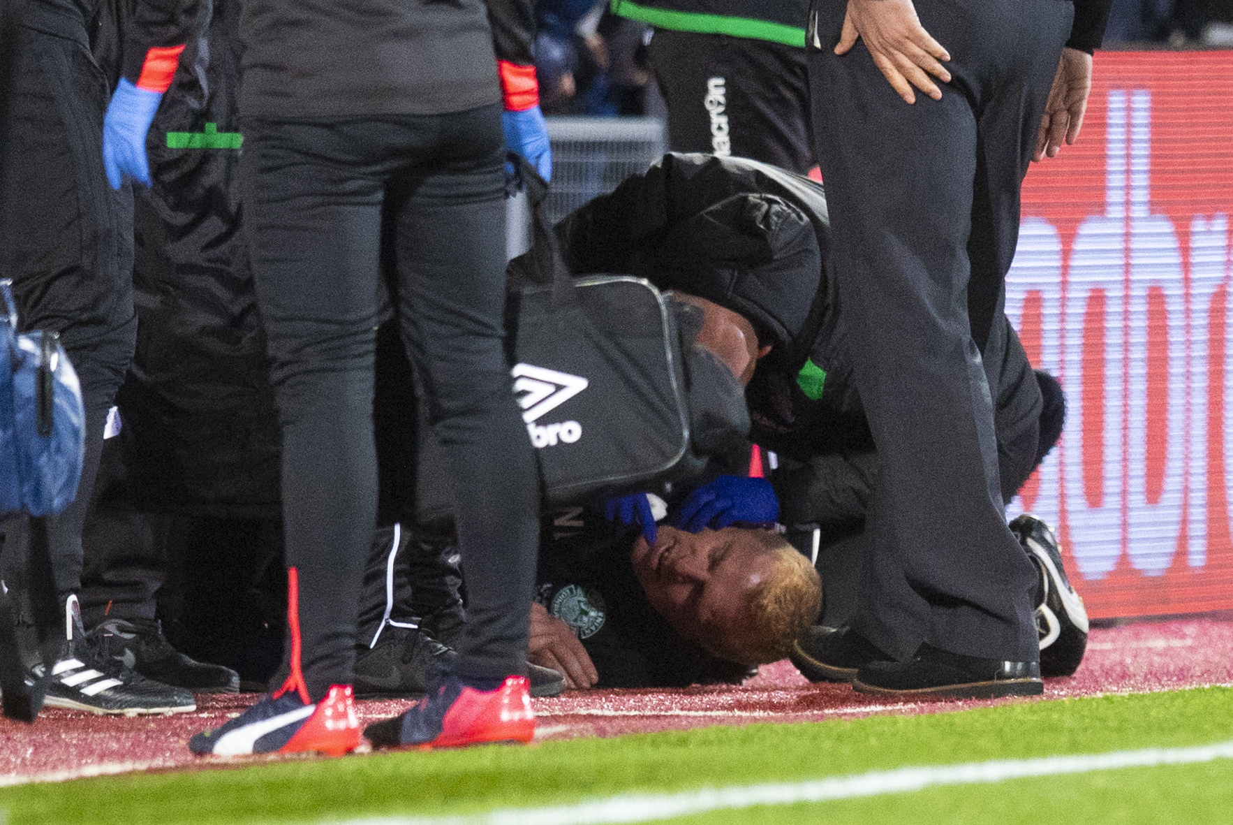 Hibernian manager Neil Lennon lies on the ground after being struct by an object from the crowd (SNS Group / Craig Williamson)