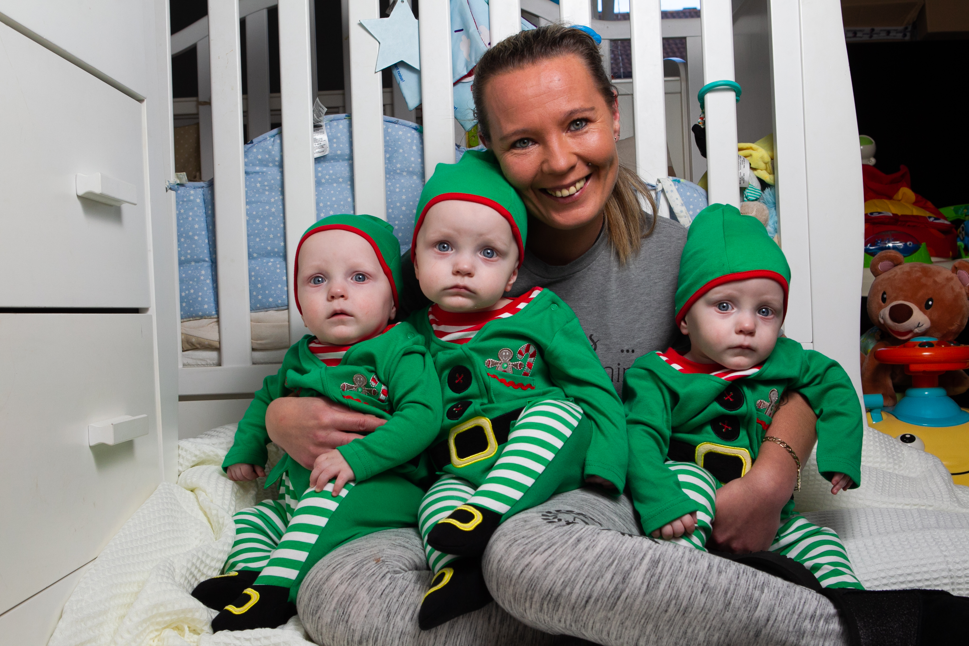 Mother Mary McCandlish and her triplet babies, wearing Christmas elf outfits. (Andrew Cawley).