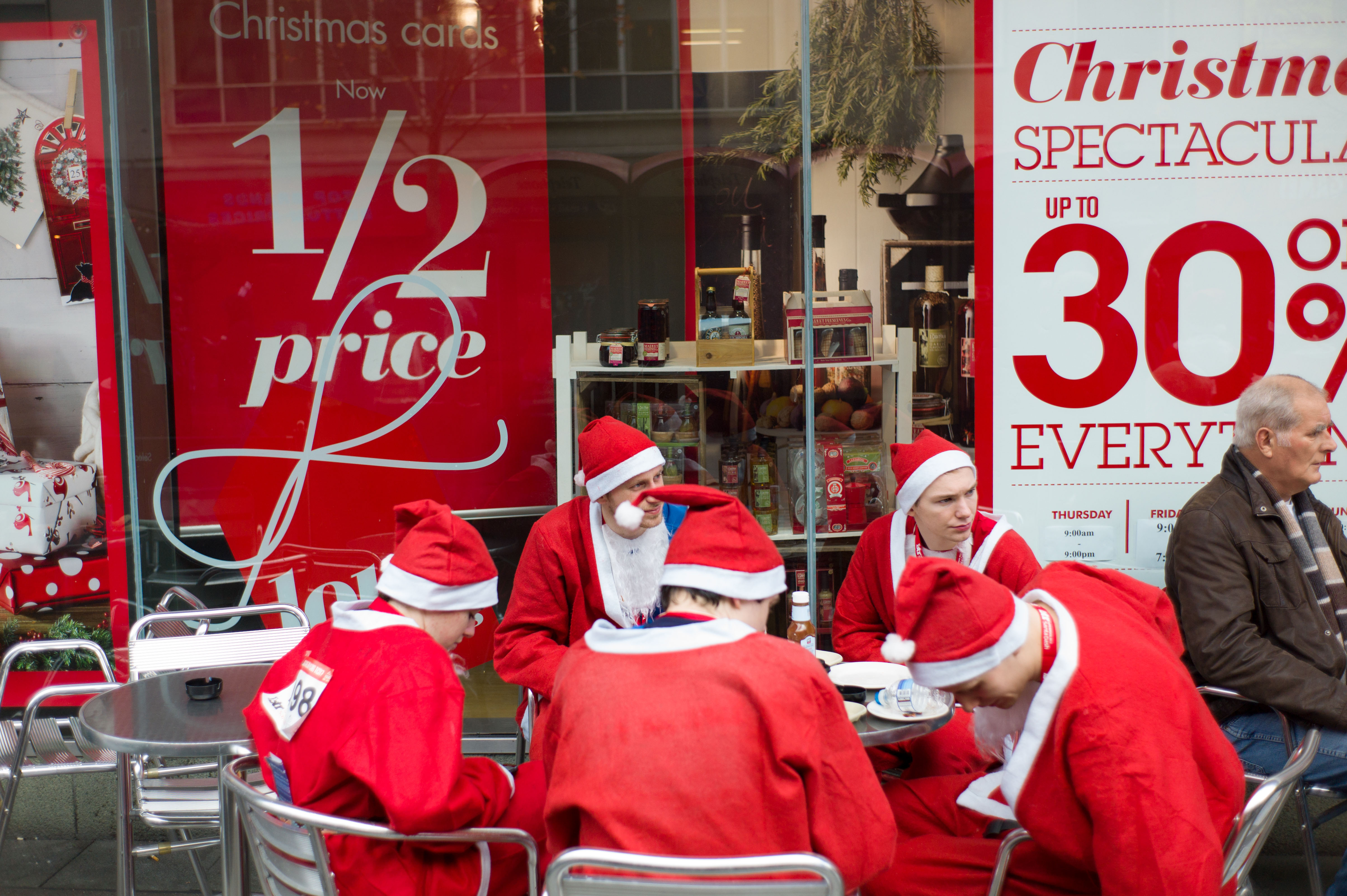 Charity Santa Dash in Liverpool runners break for a coffee at the Christmas sales.