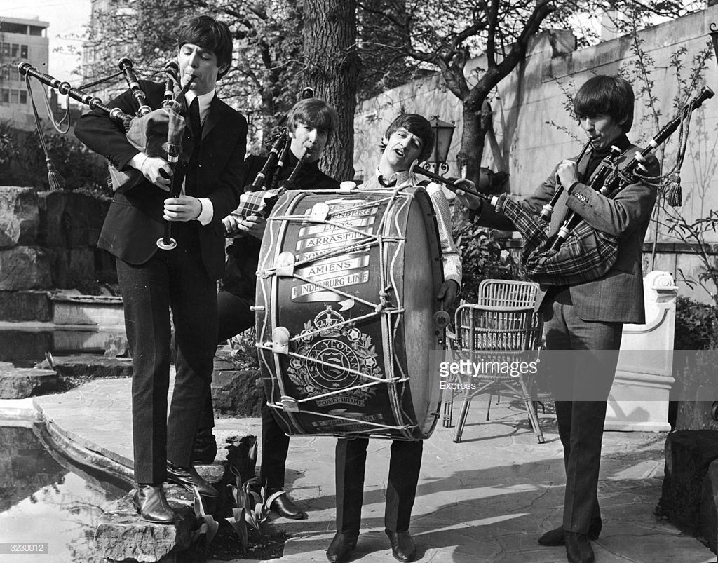 British rock group The Beatles perform on bagpipes and marching drum outdoors to promote their concerts in the Scottish cities of Glasgow and Edinburgh. L-R: Paul McCartney, John Lennon (1940 - 1980), Ringo Starr (beating the drum) and George Harrison (1943 - 2001).  (Express/Getty Images)