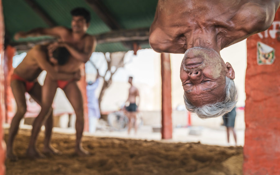 Spirit of Travel – Winner Matt Parry (UK) Varanasi, India 64-year old SiyaRam hangs from the beams above the wrestling pit in Varanasi, India, in the middle of doing stomach crunches as part of an intense warm up routine that belied his age. I was in India on an assignment and had wanted to photograph a Kushti wrestling akhara. This form of the sport is steeped in history, culture and tradition but is gradually dying out due to government pressure for participants to move on to a modern mat-based wrestling format in order to compete at international level. SiyaRam has been training in this akhara for 13 years, and what started as a hobby is now a major part of his daily life.