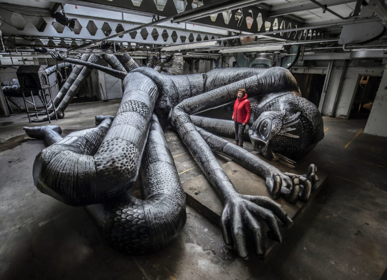 Producer Tamar Millen views one of the artworks on display during the Mausoleum of the Giants, a solo show created by artist Phlegm at the Eyewitness Works in Sheffield