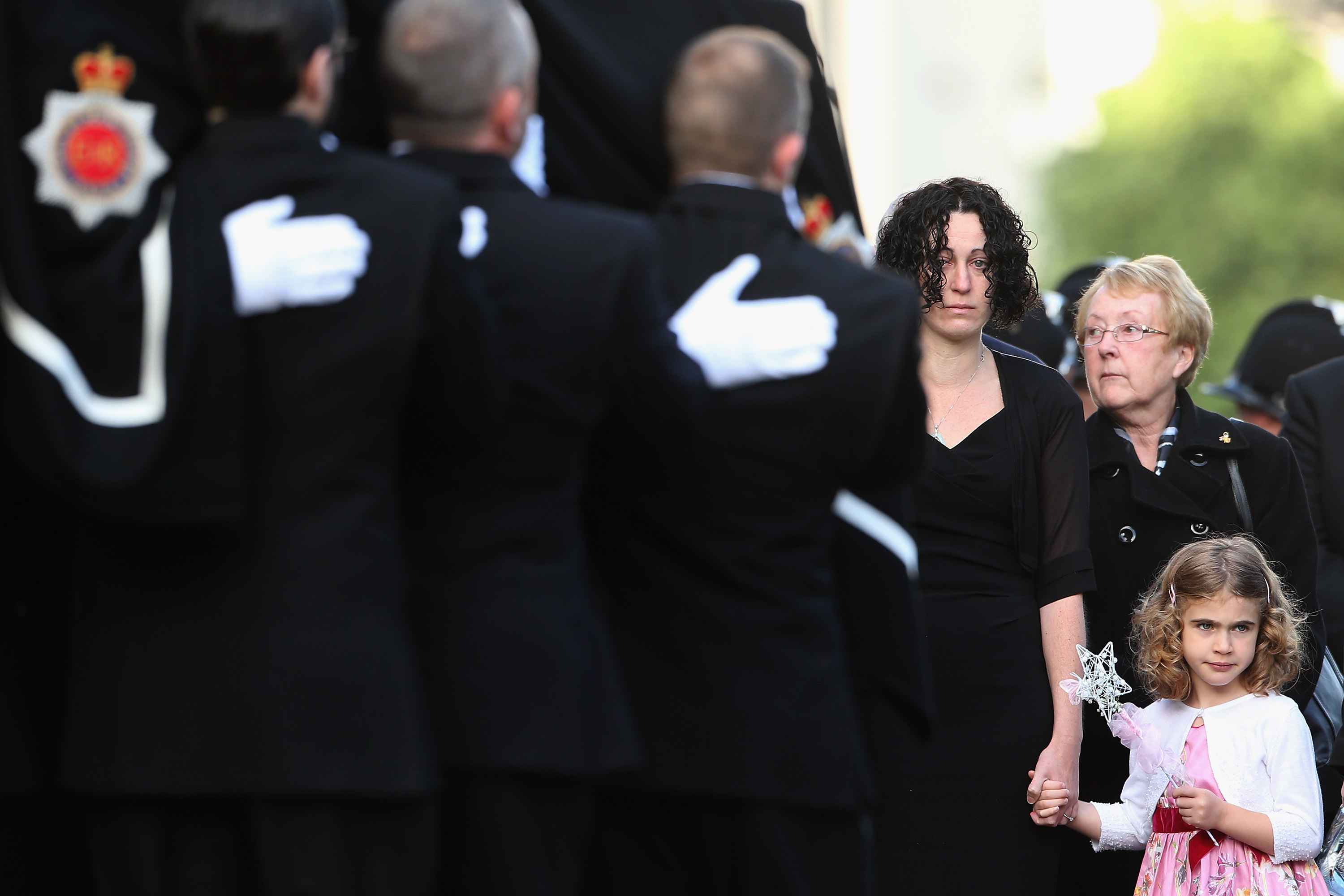 Clare Curran, the partner of murdered police officer Fiona Bone and five-year-old daughter Jessie watch as the coffin of the Greater Manchester Police constable is taken into Manchester Cathedral for her funeral service