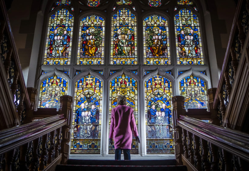 A visitor admires the newly-restored Butterfield Window at Cliffe Castle in Keighley, Yorkshire, after completion of a 10-year restoration project