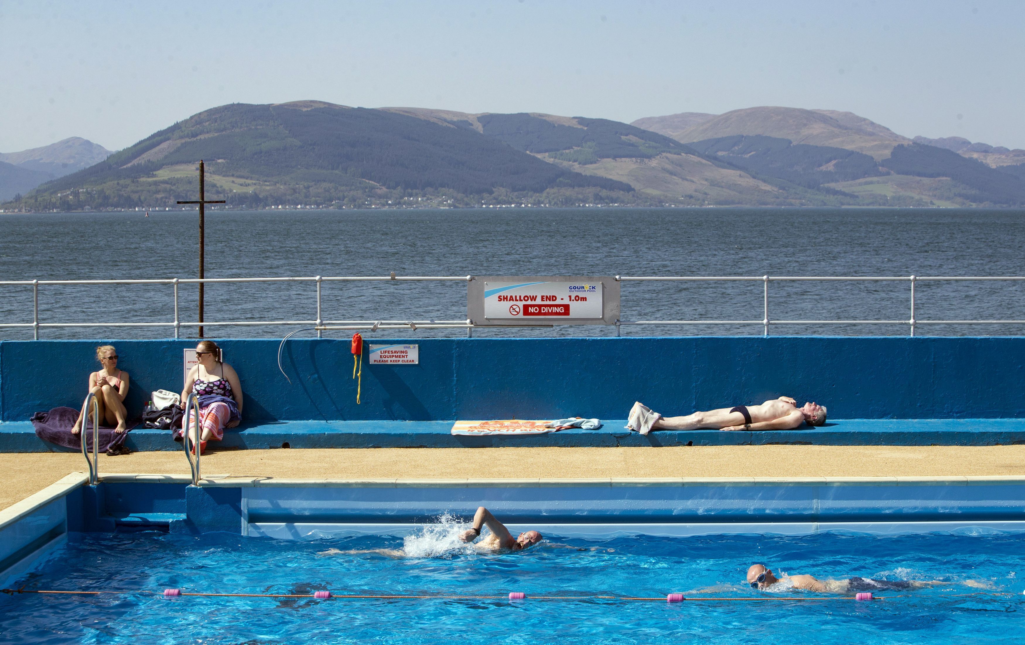 Swimmers and sunbathers enjoy the hot weather at Gourock Outdoor Pool, a heated salt water lido in Gourock, Renfrewshire.