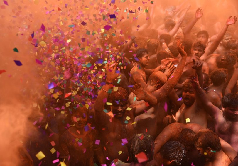 Revellers dance as they celebrate the Hindu Holi festival, or Festival of Colours, in Prayagraj in northern India