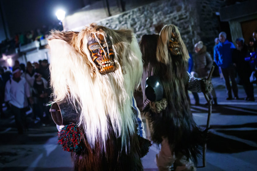 Revellers at a traditional pre-Lenten Tschäggättä carnival wearing masks and costumes parade through Blatten village in the Loetschental valley, Switzerland