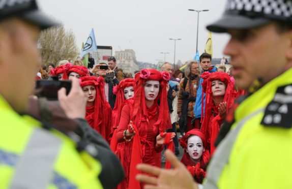 Members of Extinction Rebellion argue with police officers during a demonstration at Waterloo Bridge