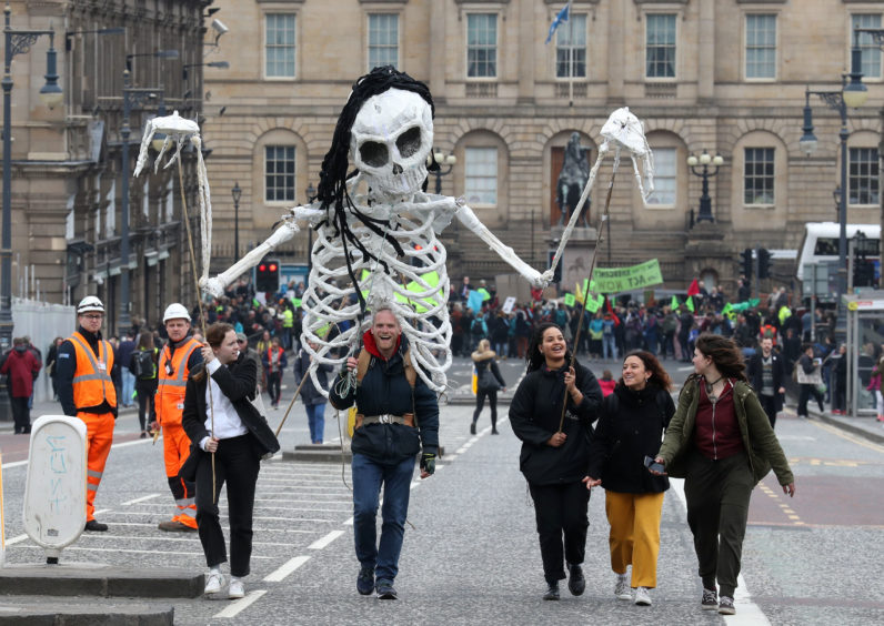 Supporters of Extinction Rebellion Scotland join climate change protesters in forming a road block on the North Bridge in Edinburgh on Tuesday