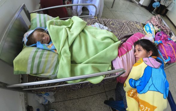 A distraught mother lies next to the bed of her undernourished baby in a hospital in Maracay in northern Venezuela as a shortage of food and medicines is hitting the population hard