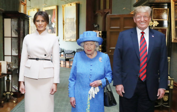 Queen Elizabeth II stands with US President Donald Trump and his wife, Melania, in the Grand Corridor during their visit to Windsor Castle in Berkshire